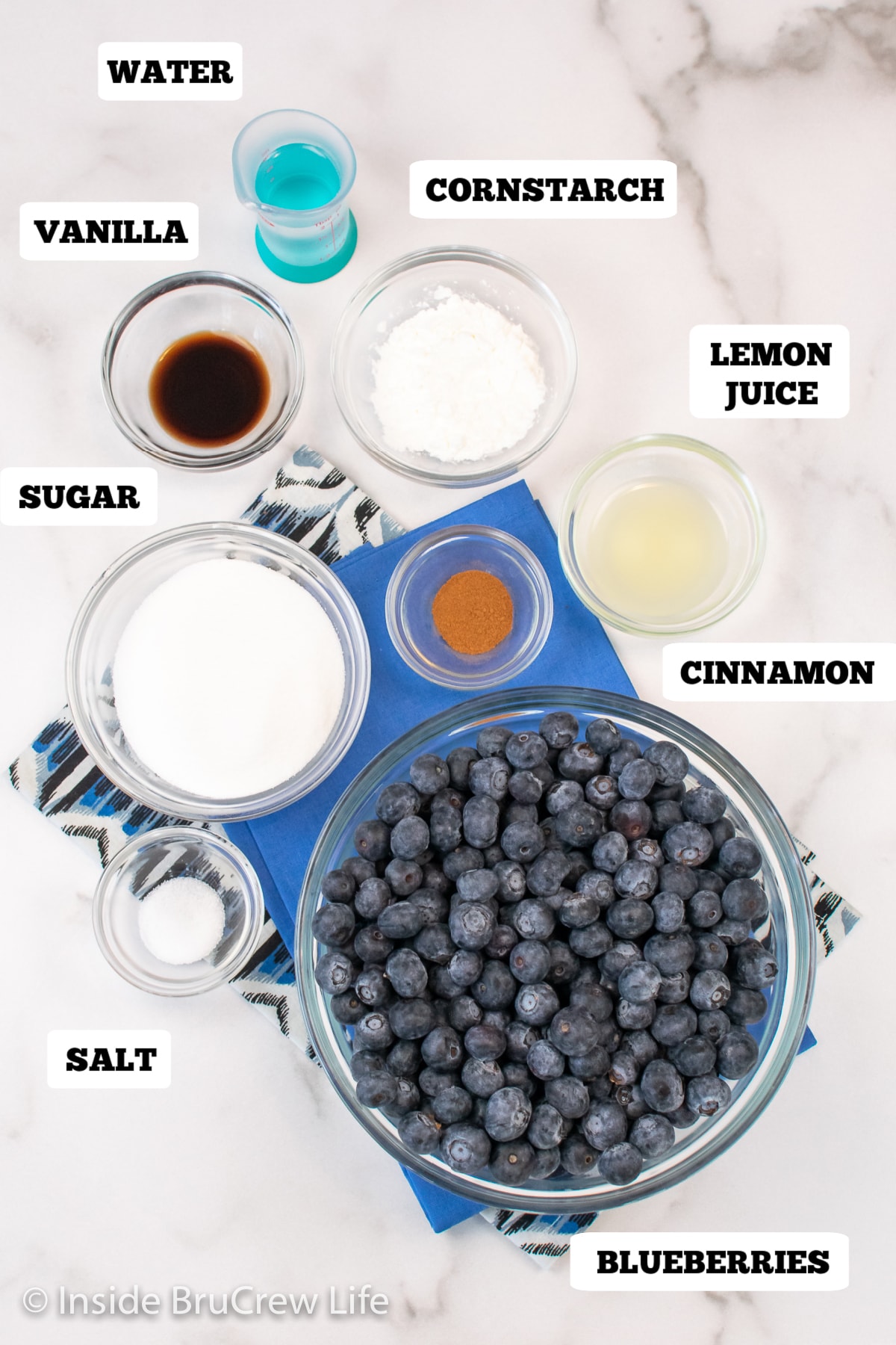 A white board with bowls of ingredients to make homemade pie filling on it.