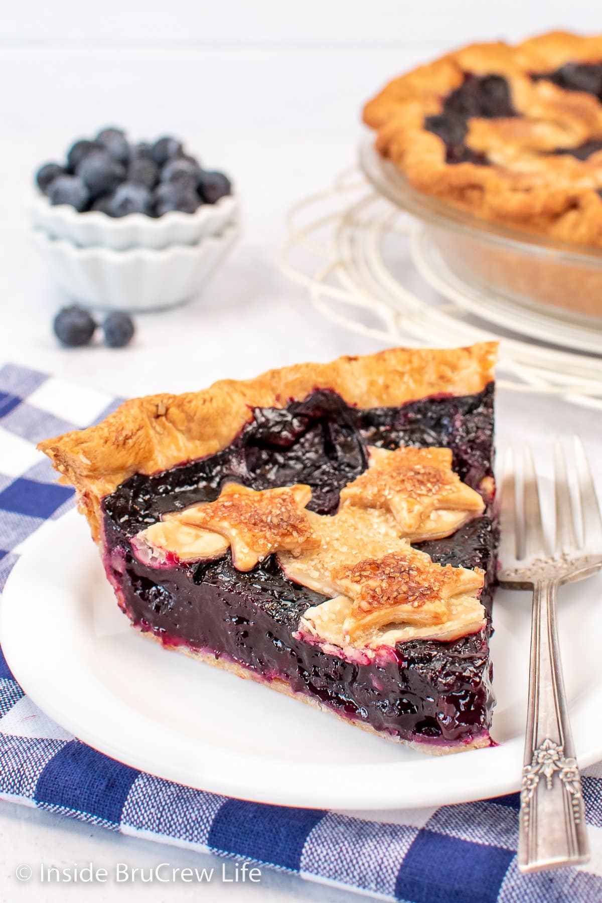 A white plate with a slice of pie on it.