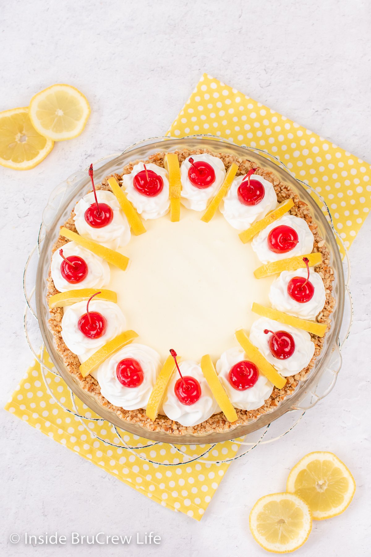 Overhead picture of a pie decorated with cherries.