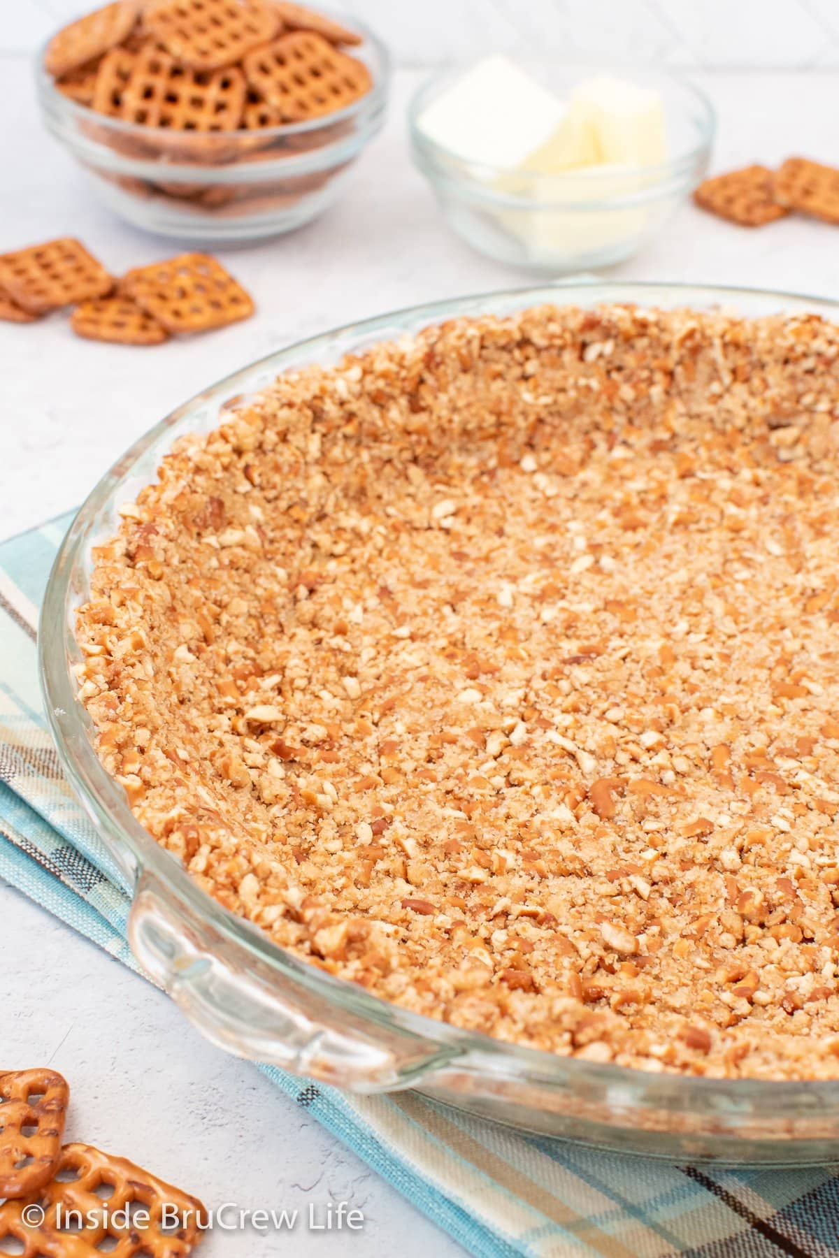 Glass pie plate with crumb pie crust in it.