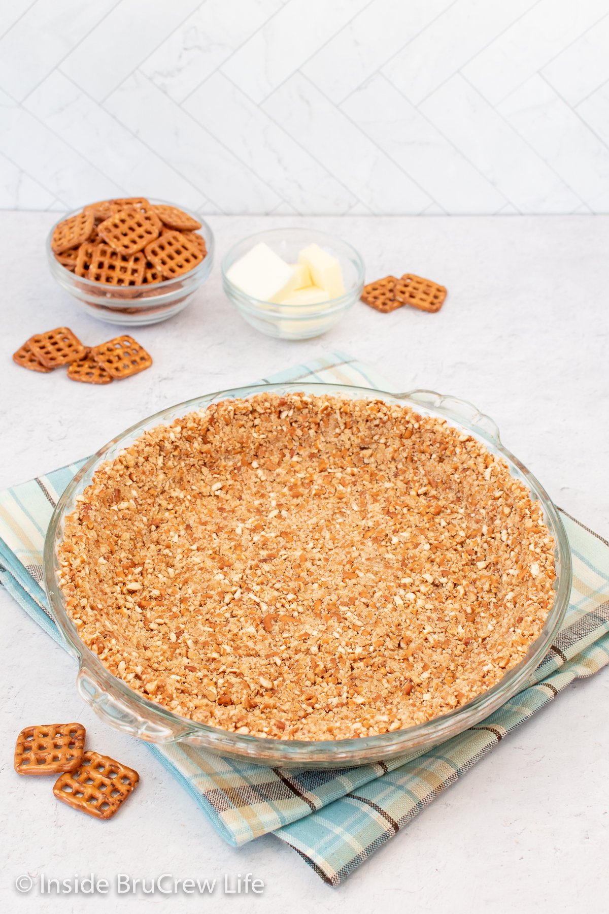 A glass pie plate with a crust in it.