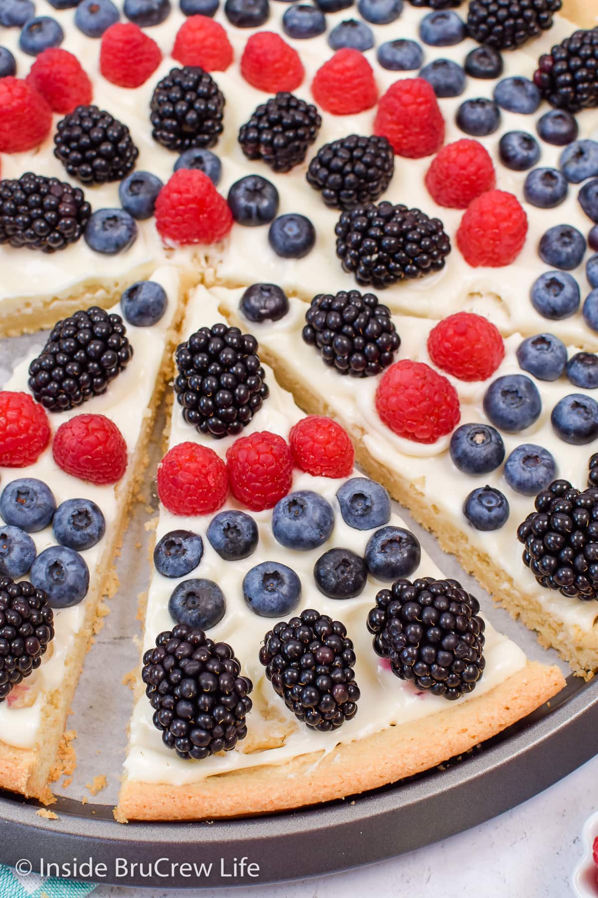 Close up of a slice of dessert pizza with berries.