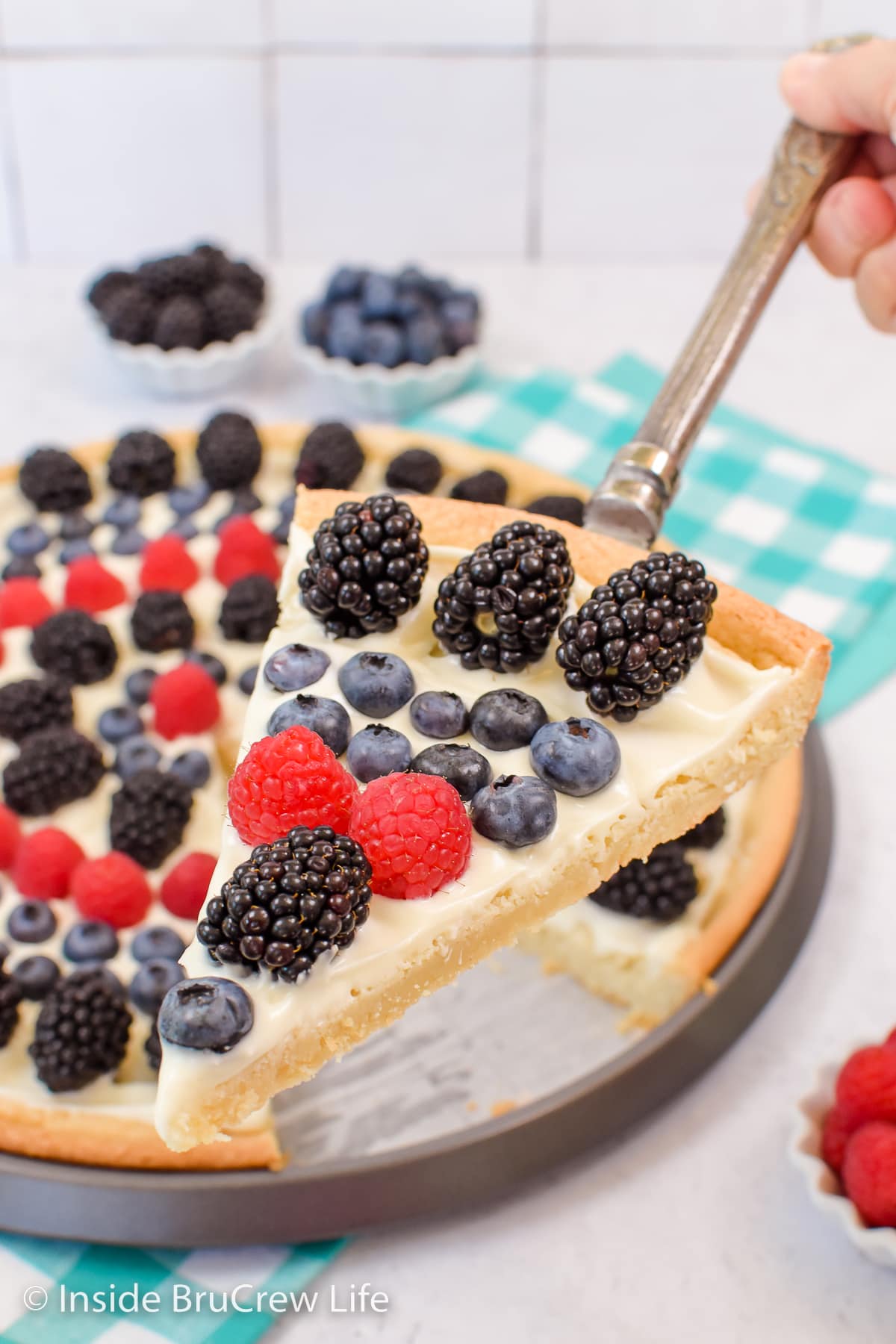 A slice of berry pizza on a spatula.