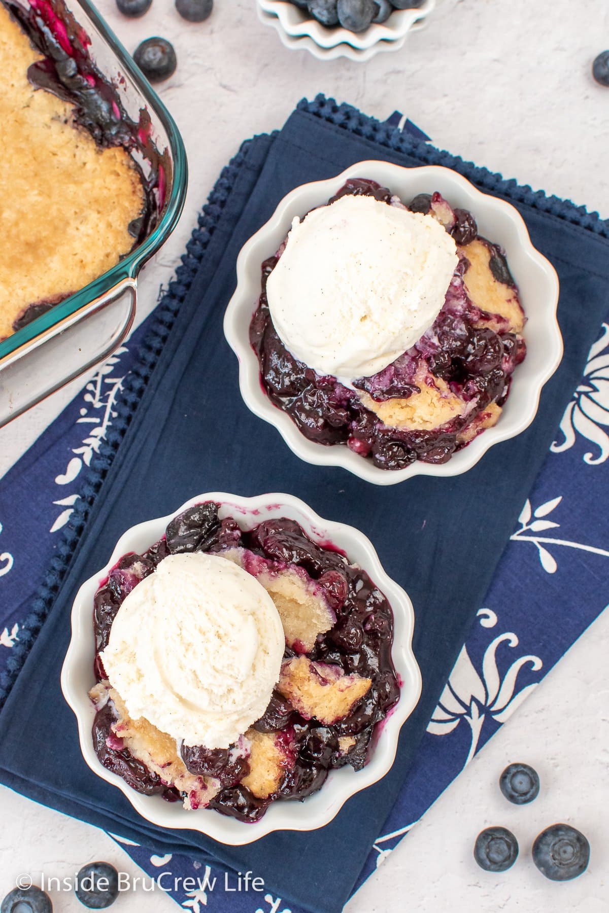 Two bowls of fruit topped with a biscuit topping.