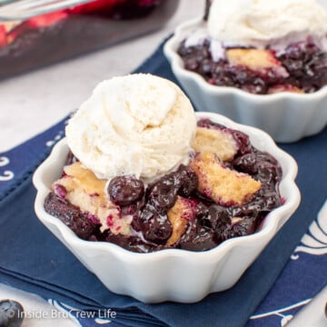 Fruit cobbler in a white bowl with vanilla ice cream.