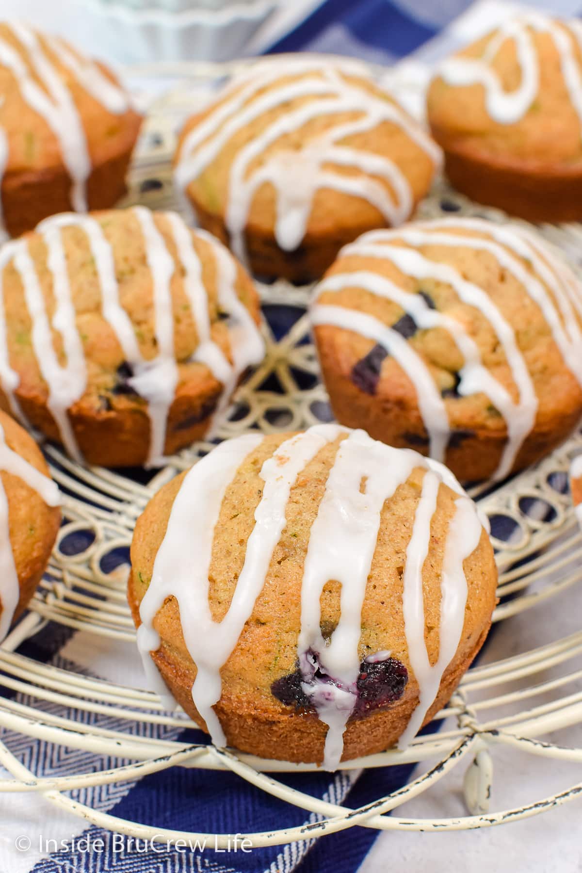 Muffins on a wire rack drizzled with a white glaze.