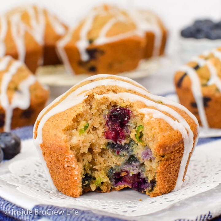 A muffin with blueberries inside with a bite take out of it.
