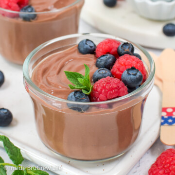 A glass bowl filled with chocolate pudding and fresh berries.