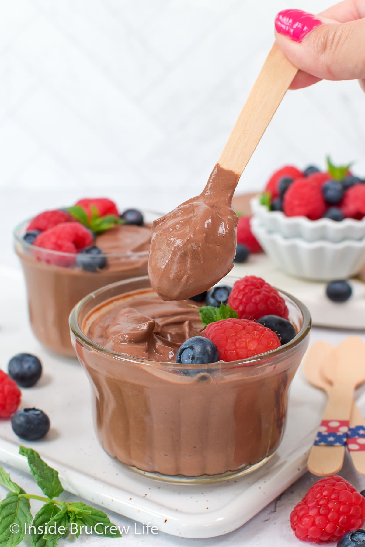 A bowl of chocolate pudding with a spoon.