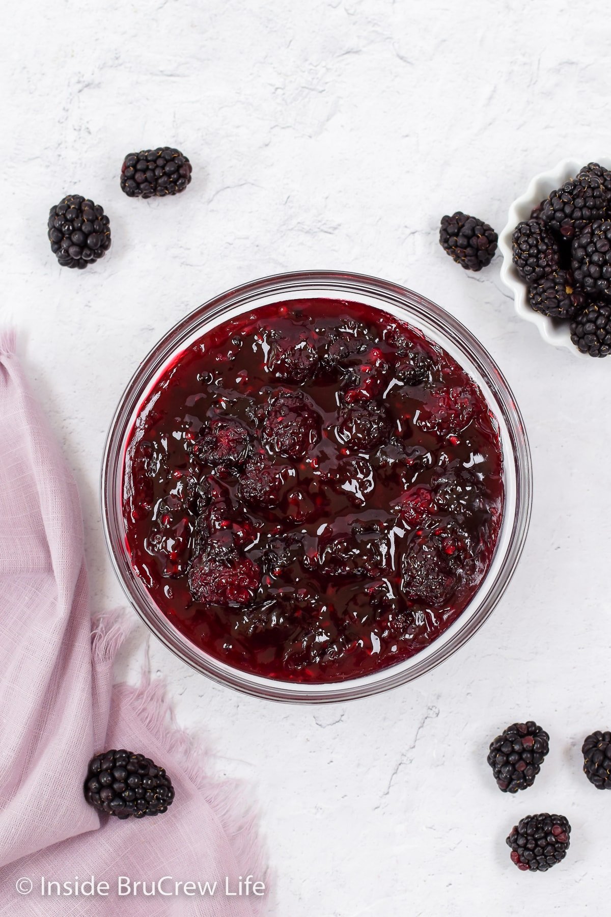 A glass bowl filled with berry pie filling.