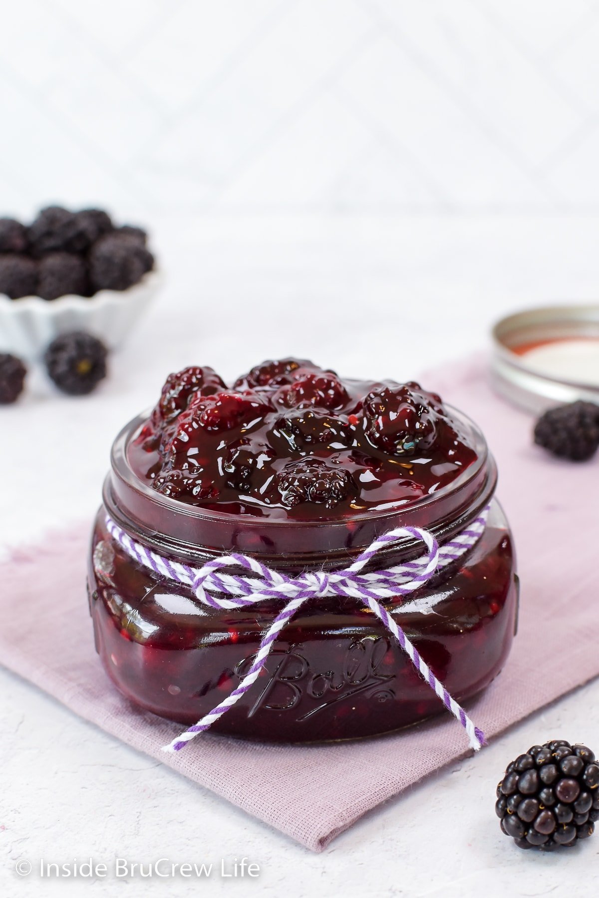 A glass jar filled with homemade blackberry pie filling.
