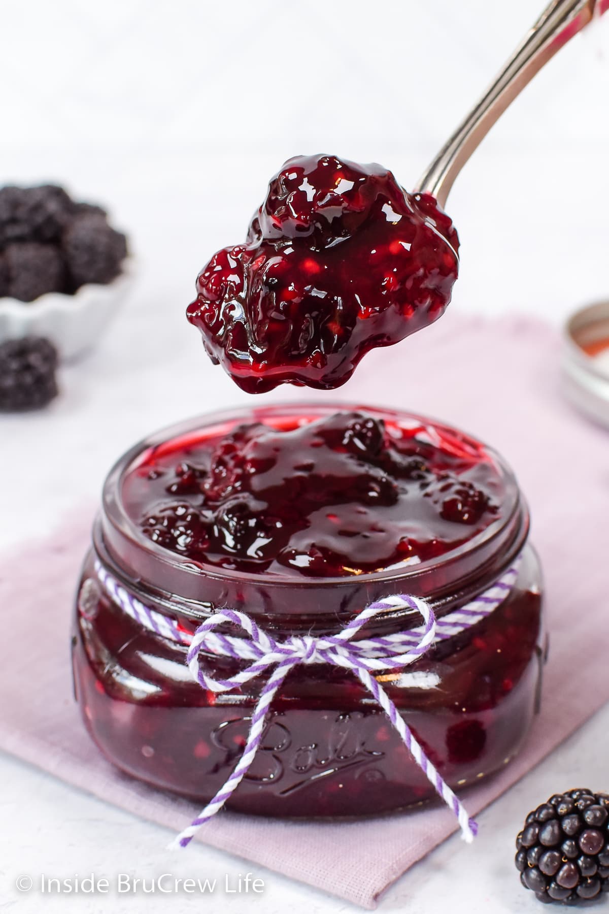 A jar of pie filling with a spoon lifting some out.