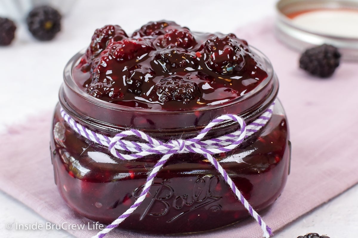 A glass jar filled with homemade blackberry pie filling.