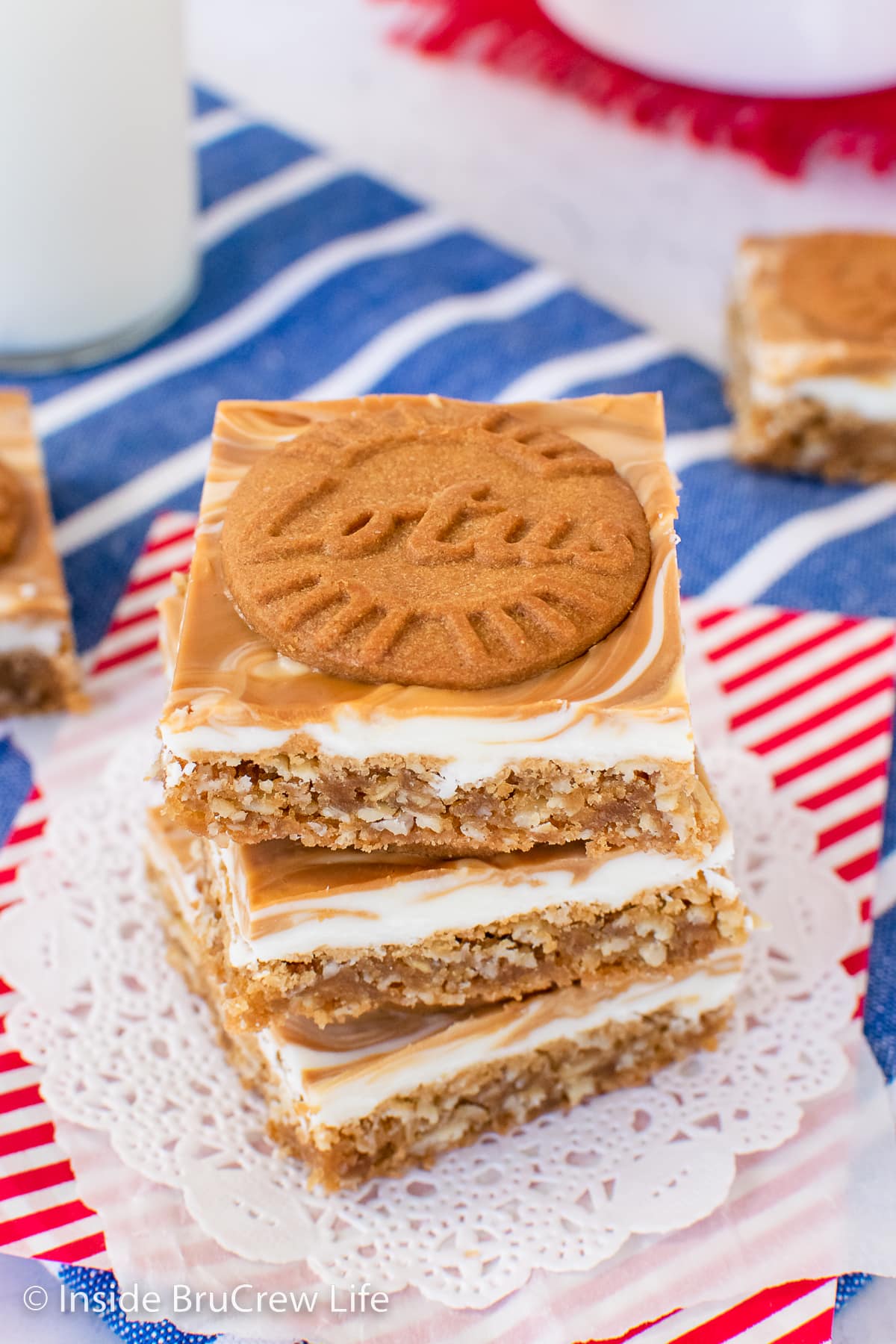 A stack of three oatmeal bars topped with white chocolate and cookies.