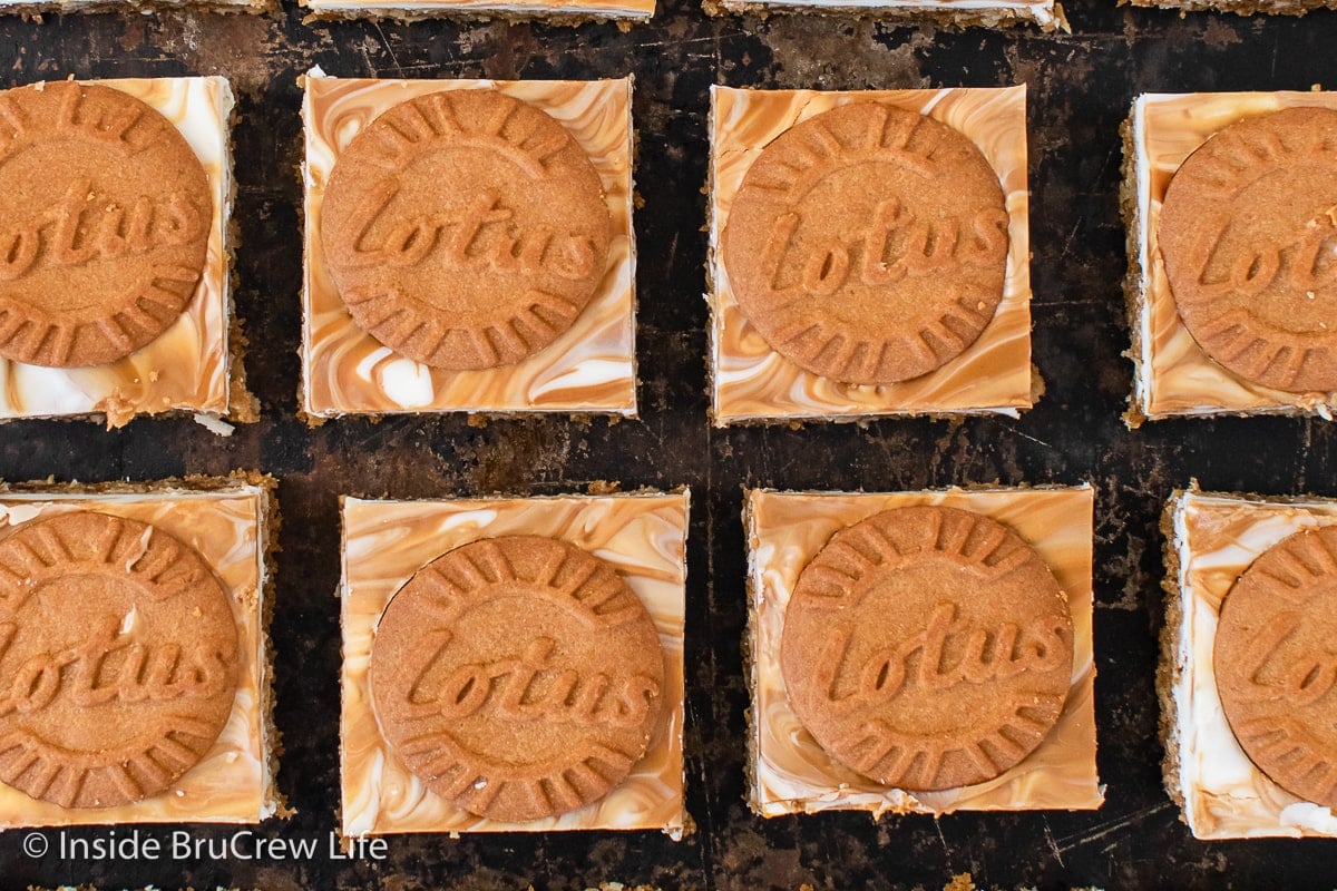 A black tray with cookie bars lined up on it.