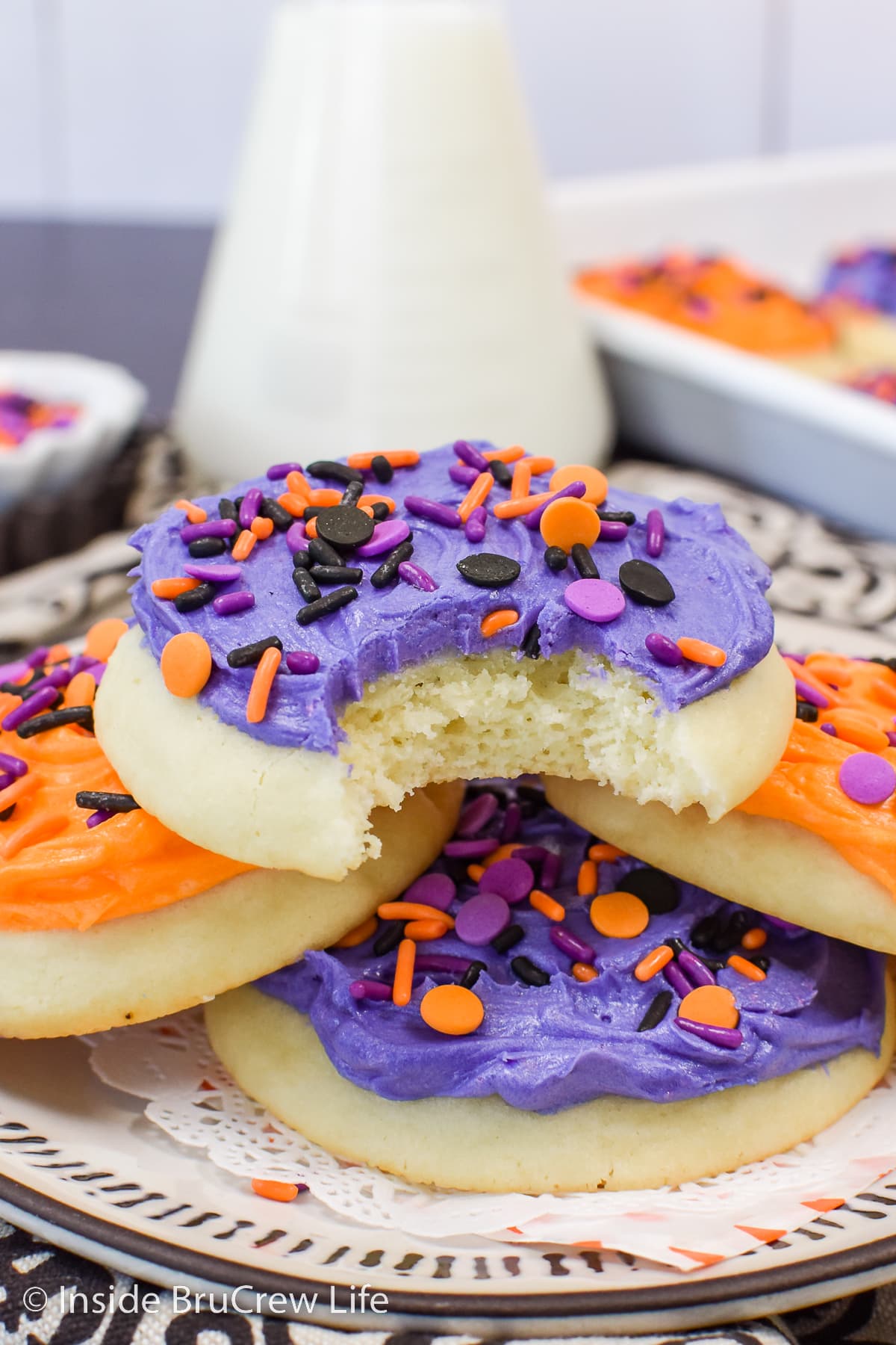 A stack of frosted cookies on a plate.