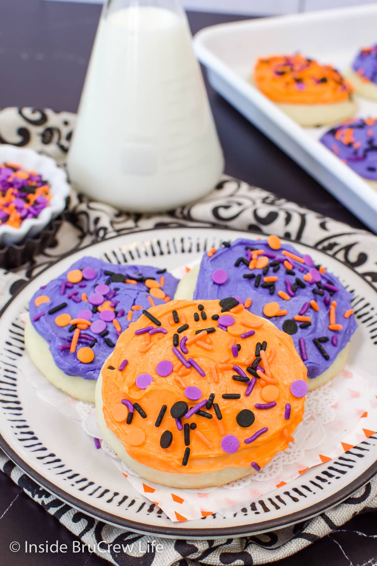 Three frosted cookies on a plate.