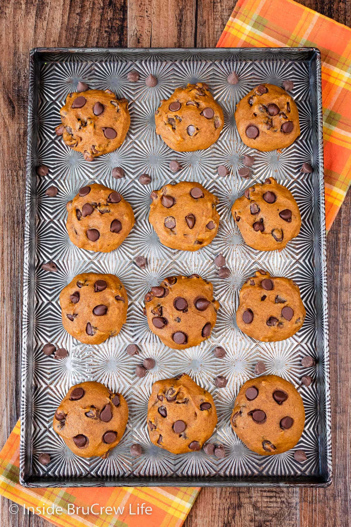 A sheet pan with pumpkin cookies on it.