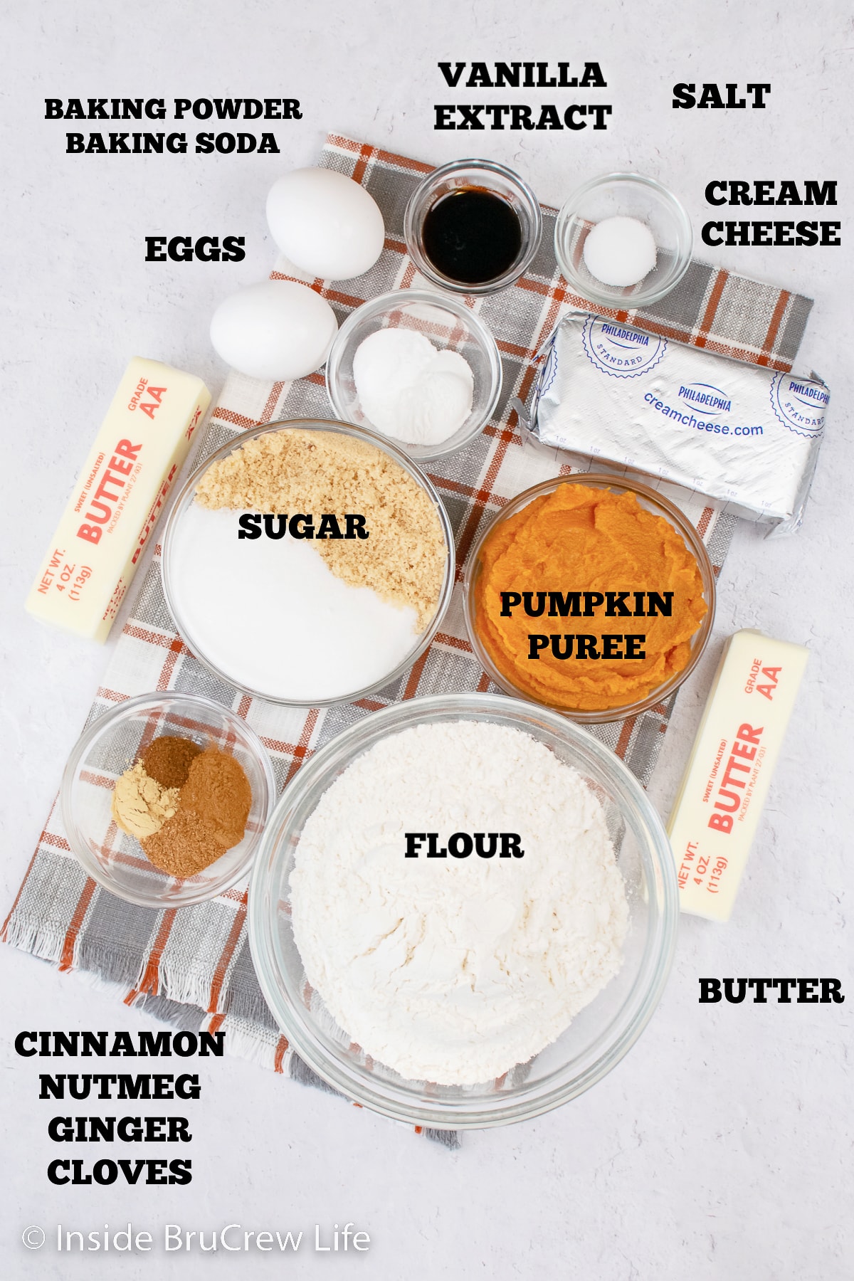 A white board with bowls of ingredients needed to make a pumpkin coffee cake.