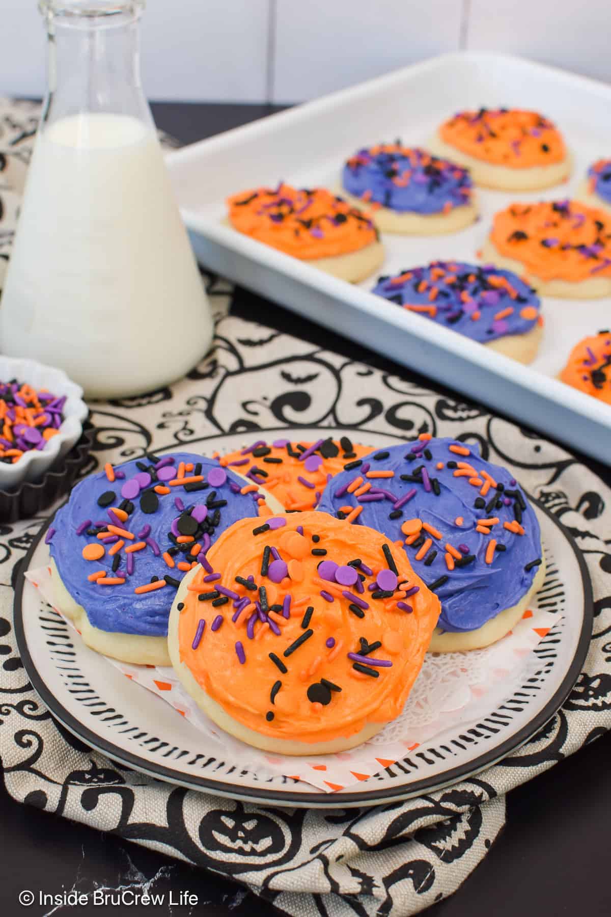 Frosted sugar cookies stacked on a plate.