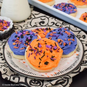 Frosted sugar cookies stacked on a plate.