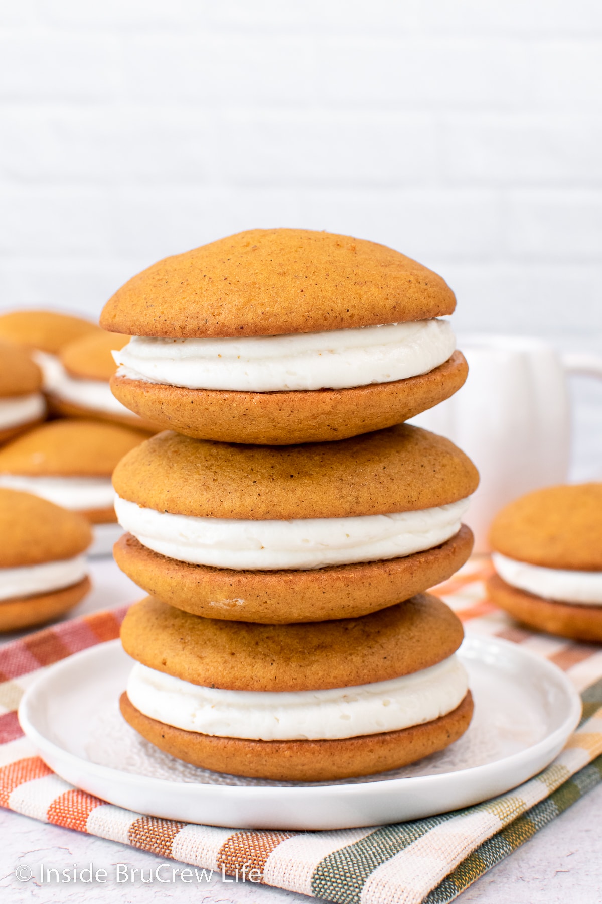 Three whoopie pies stacked on top of a white plate.