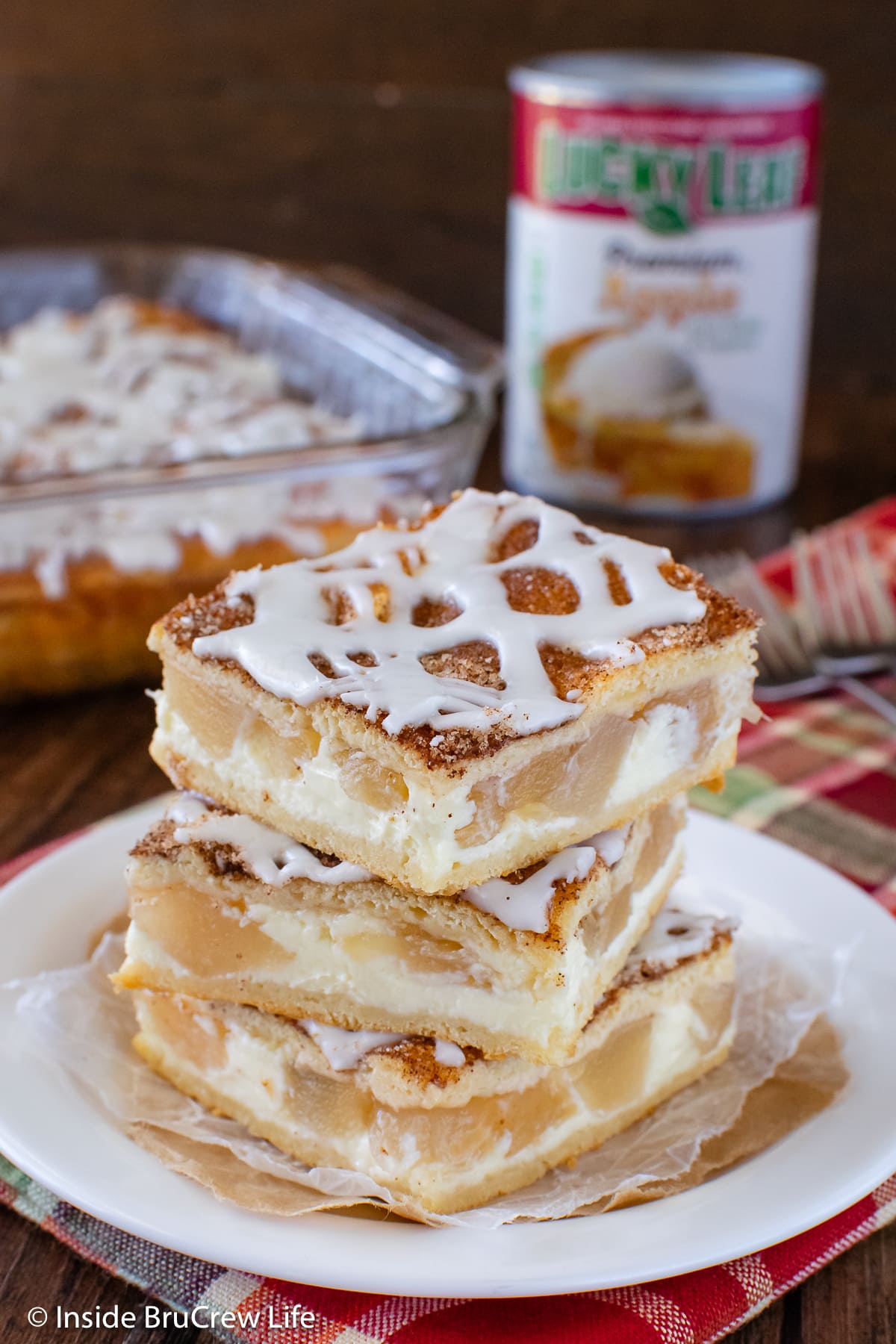 Three cinnamon apple bars stacked on a plate.