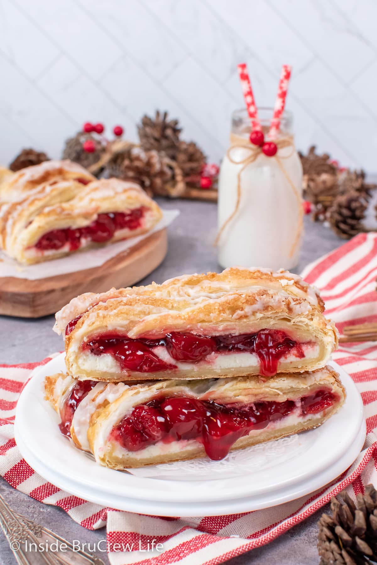 Slices of cherry danish stacked on a white plate.