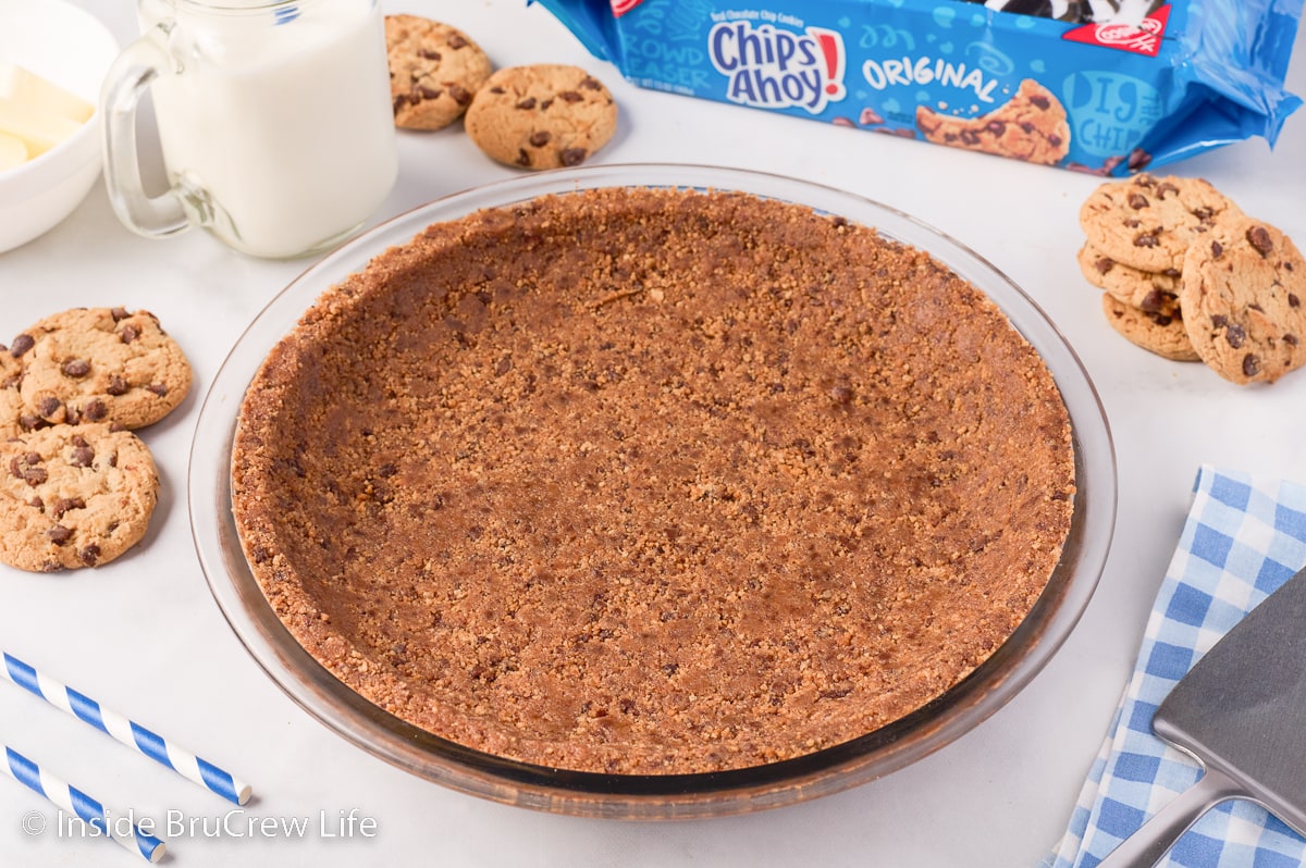A glass pie plate filled with a cookie crust.