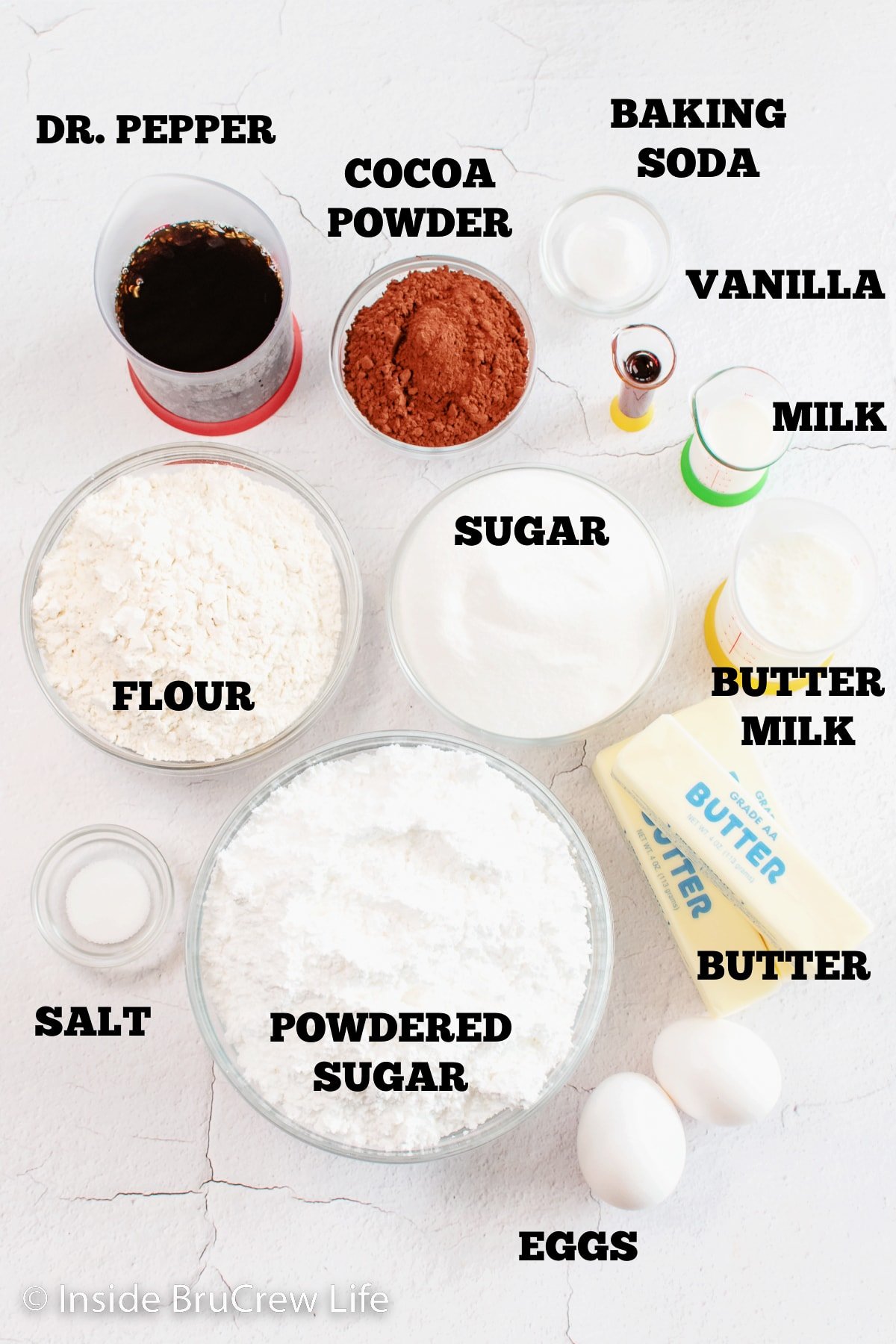 A white board with bowls of ingredients needed to make Dr. Pepper cake.