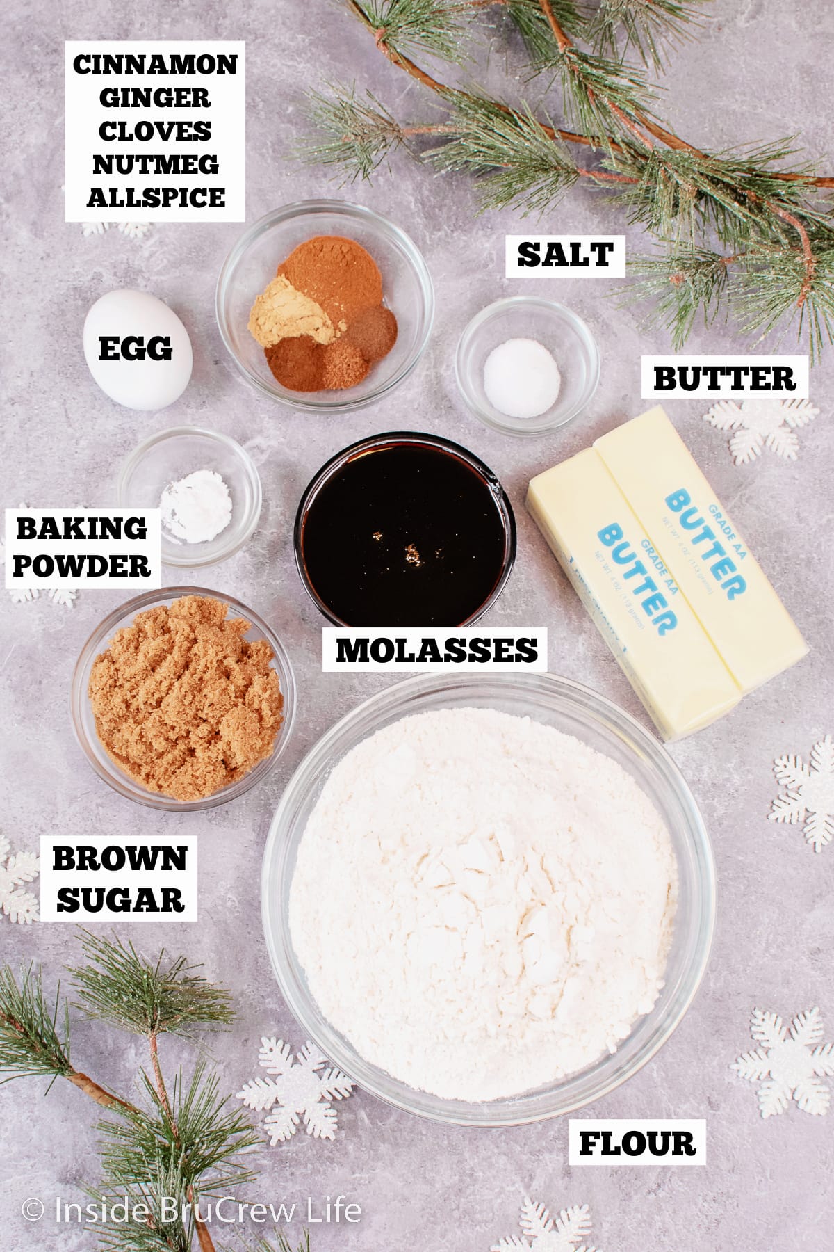 A gray board with bowls of ingredients needed for gingerbread.