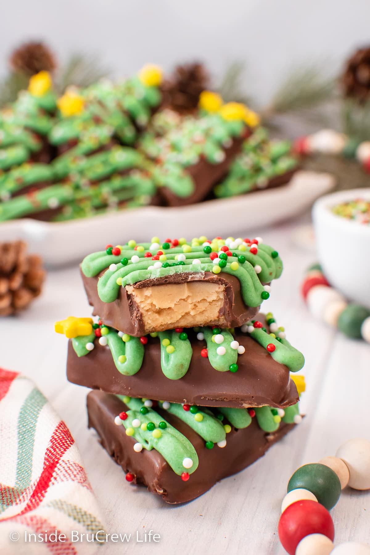 Three chocolate covered peanut butter trees stacked on a white board.