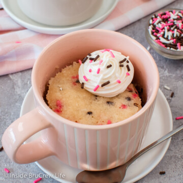A pink cup with a little funfetti cake in it.