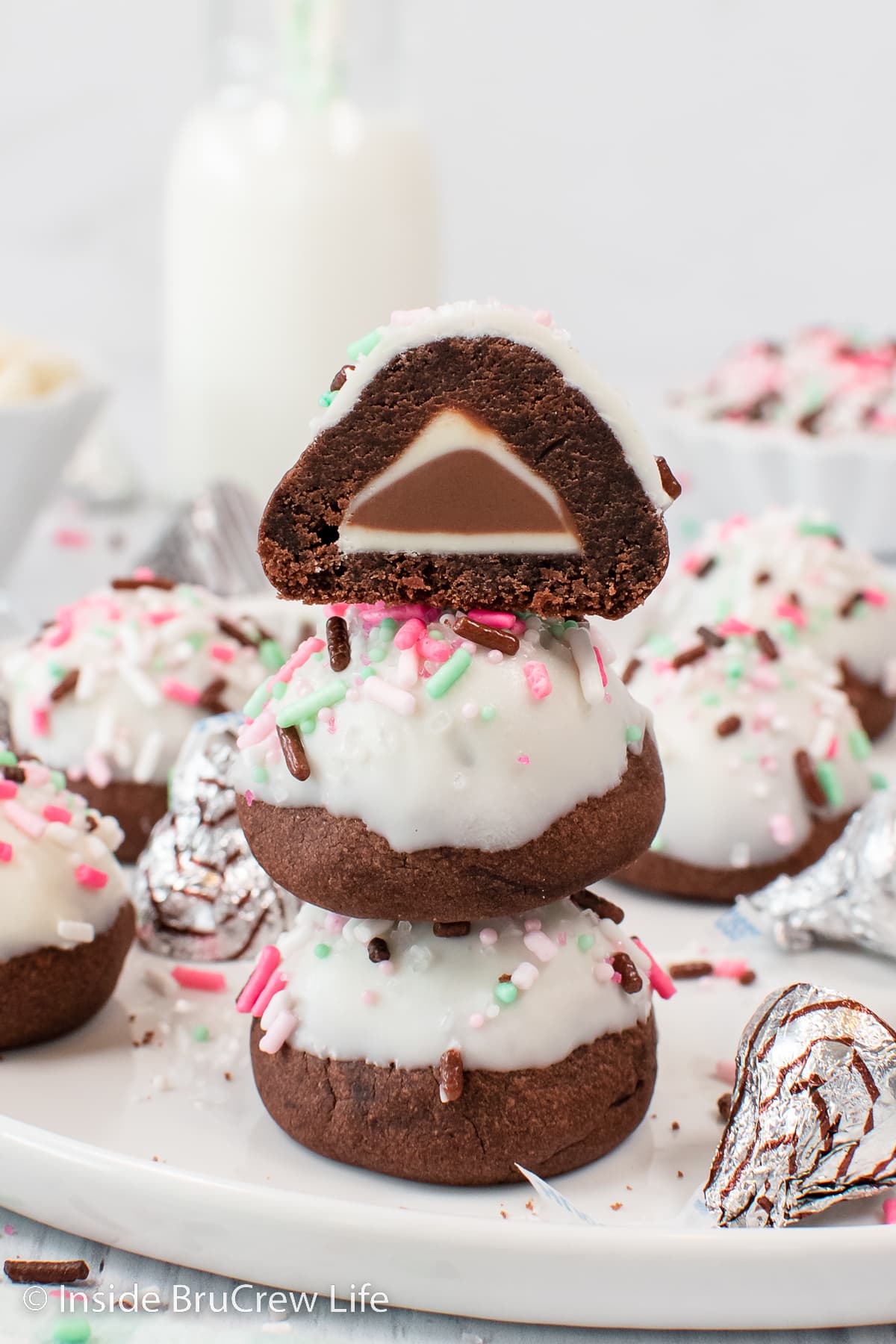 A stack of three bon bon cookies with the top one cut in half.