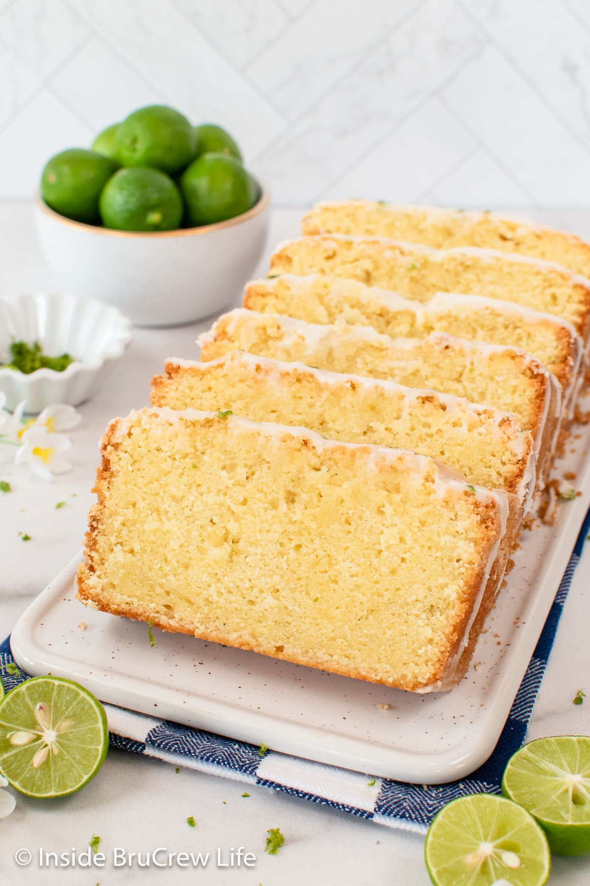 A stack of pound cake slices with glaze on a white plate.