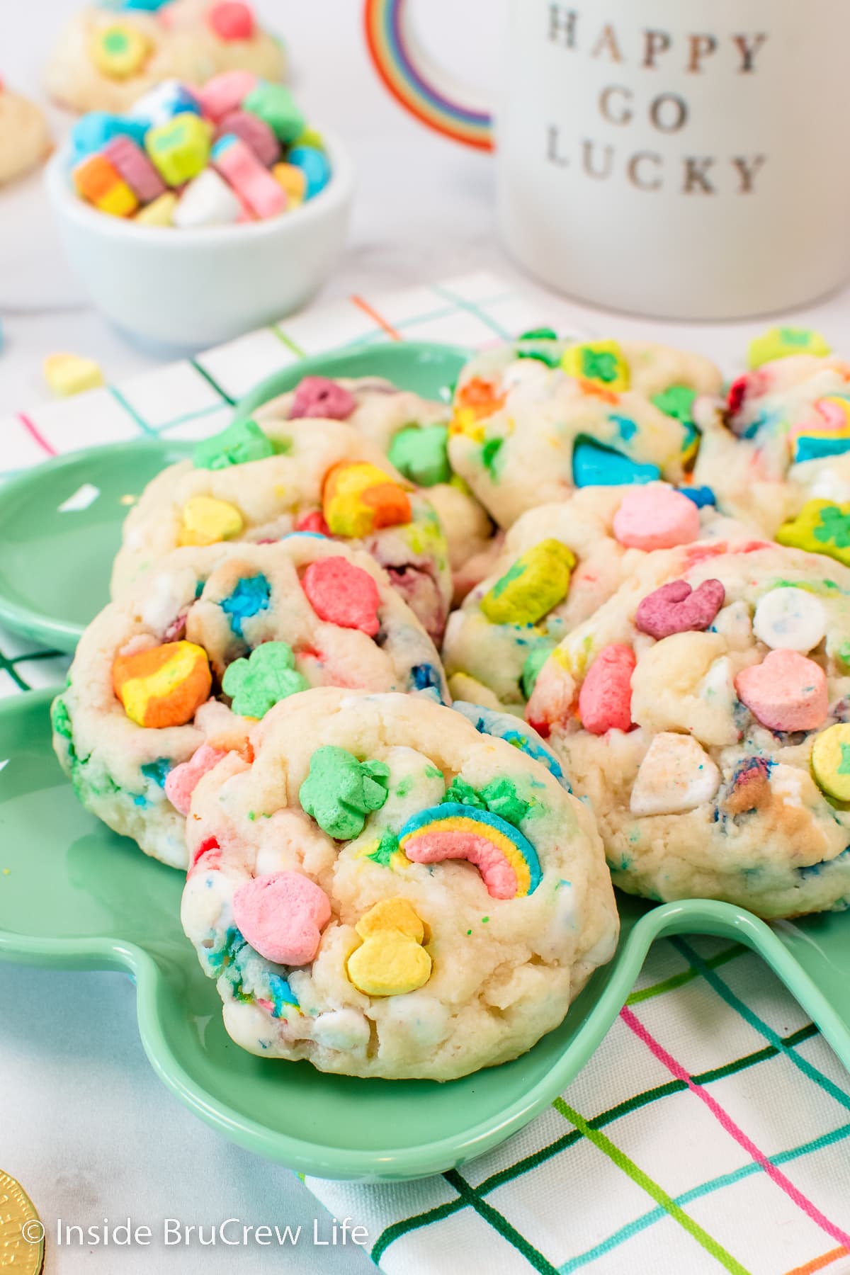 A green plate with marshmallow cookies stacked on it.