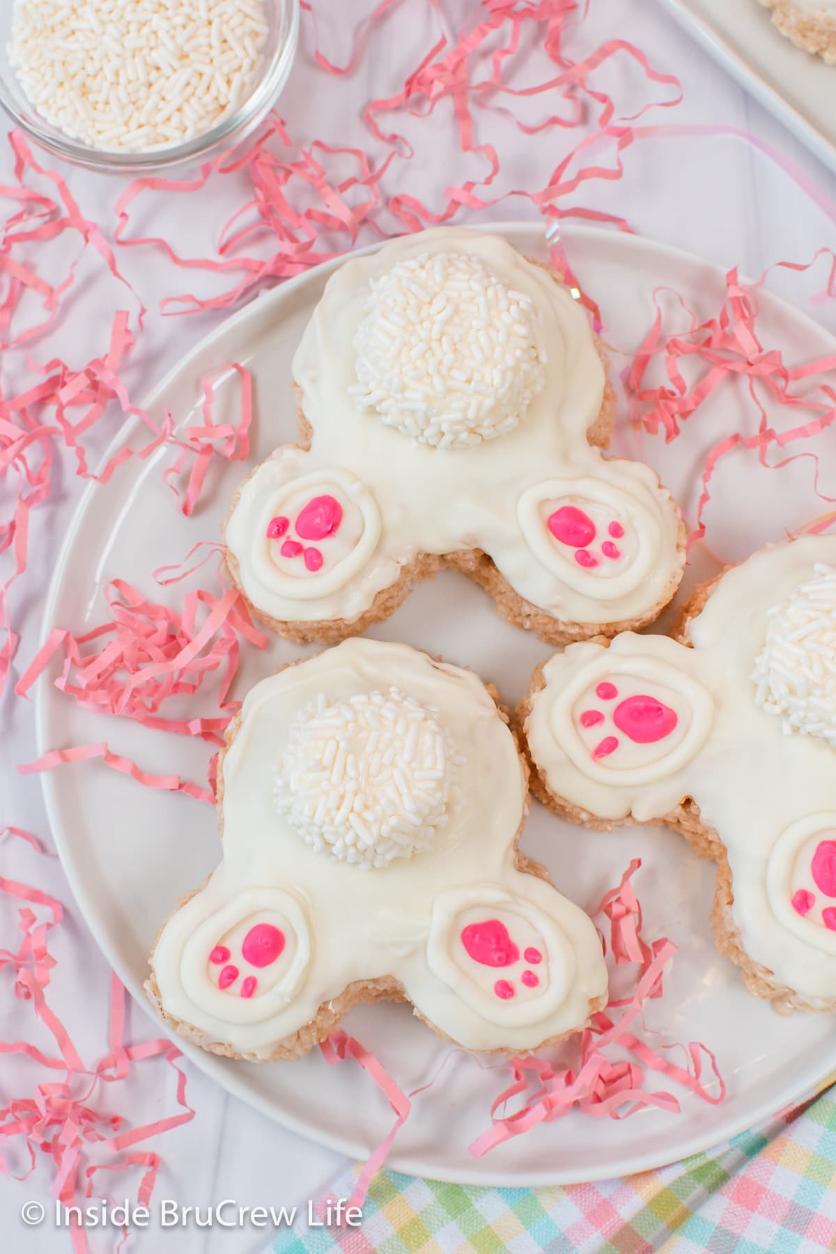 White chocolate covered bunny rice krispie treats on a white plate.