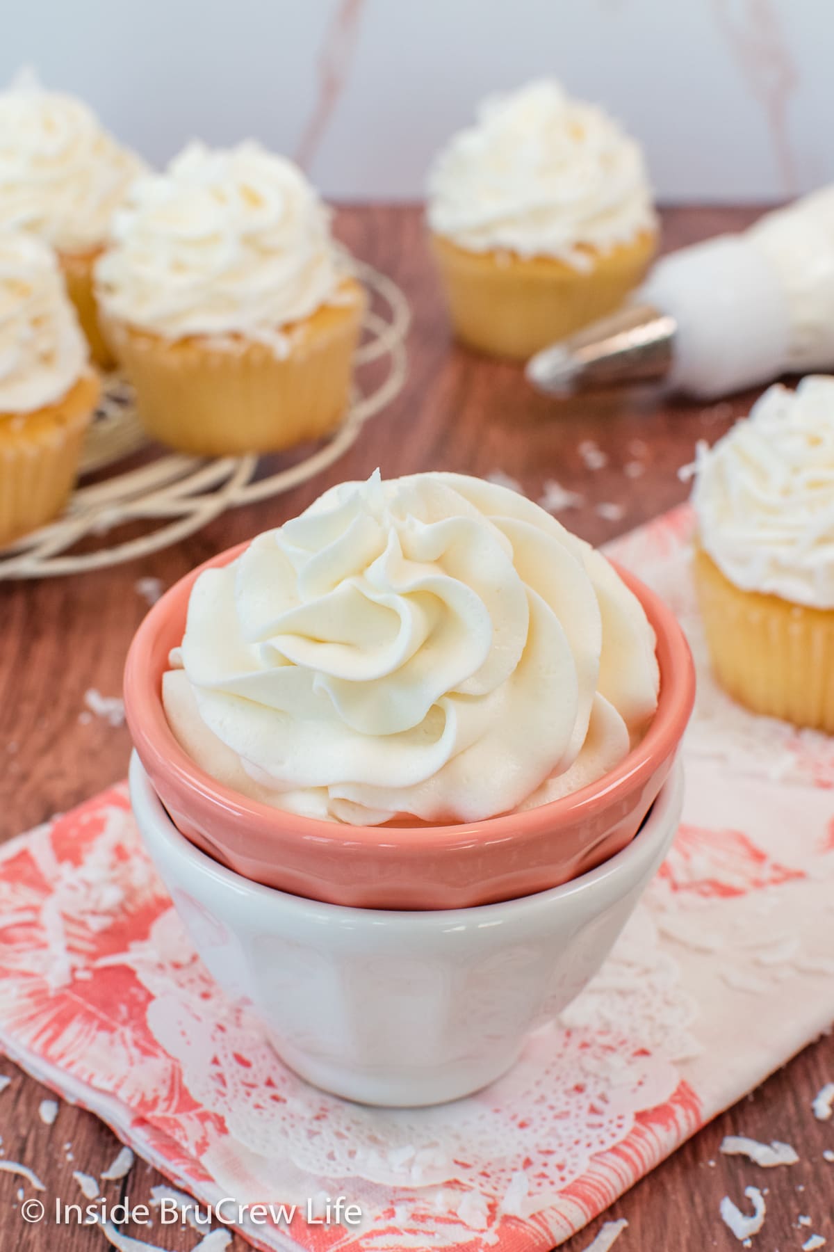 A bowl filled with a large swirl of creamy coconut frosting.