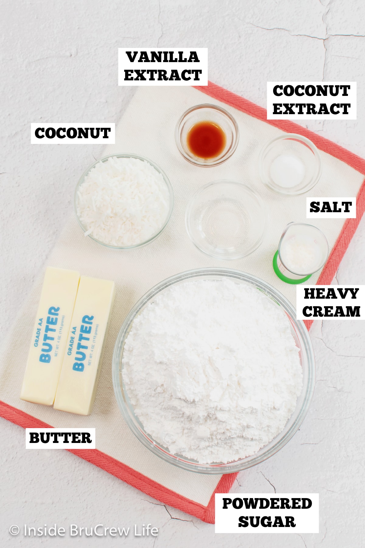 A white board with bowls of ingredients needed to make coconut icing.