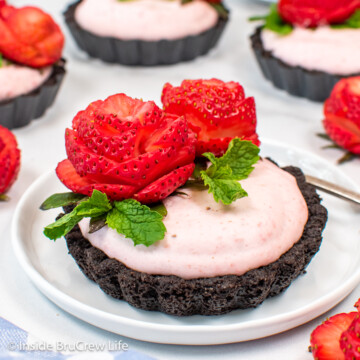 Strawberry tarts with Oreo crusts on white plates.