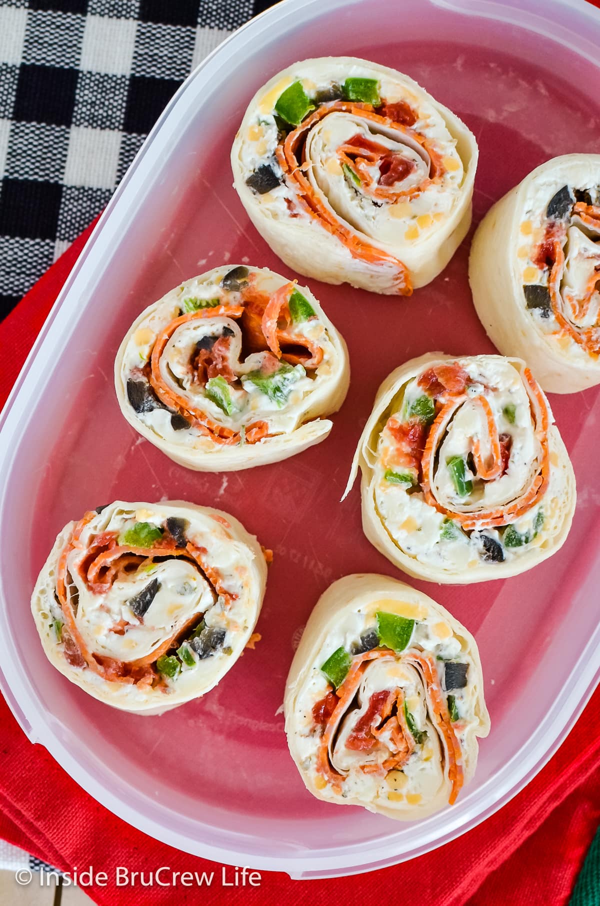 Six pizza rolls in a clear container.