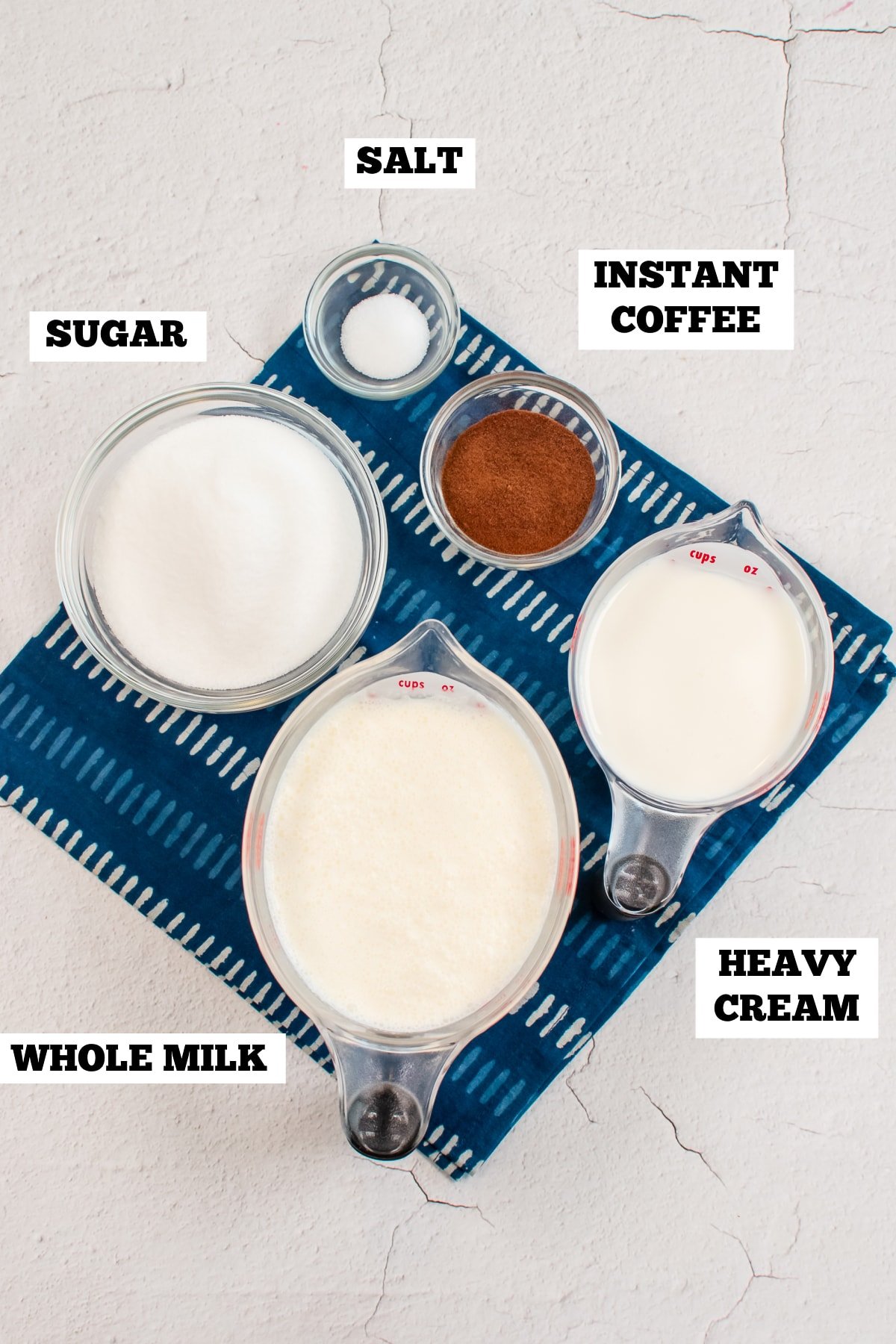 A white board with bowls of ingredients needed to make homemade ice cream with coffee.