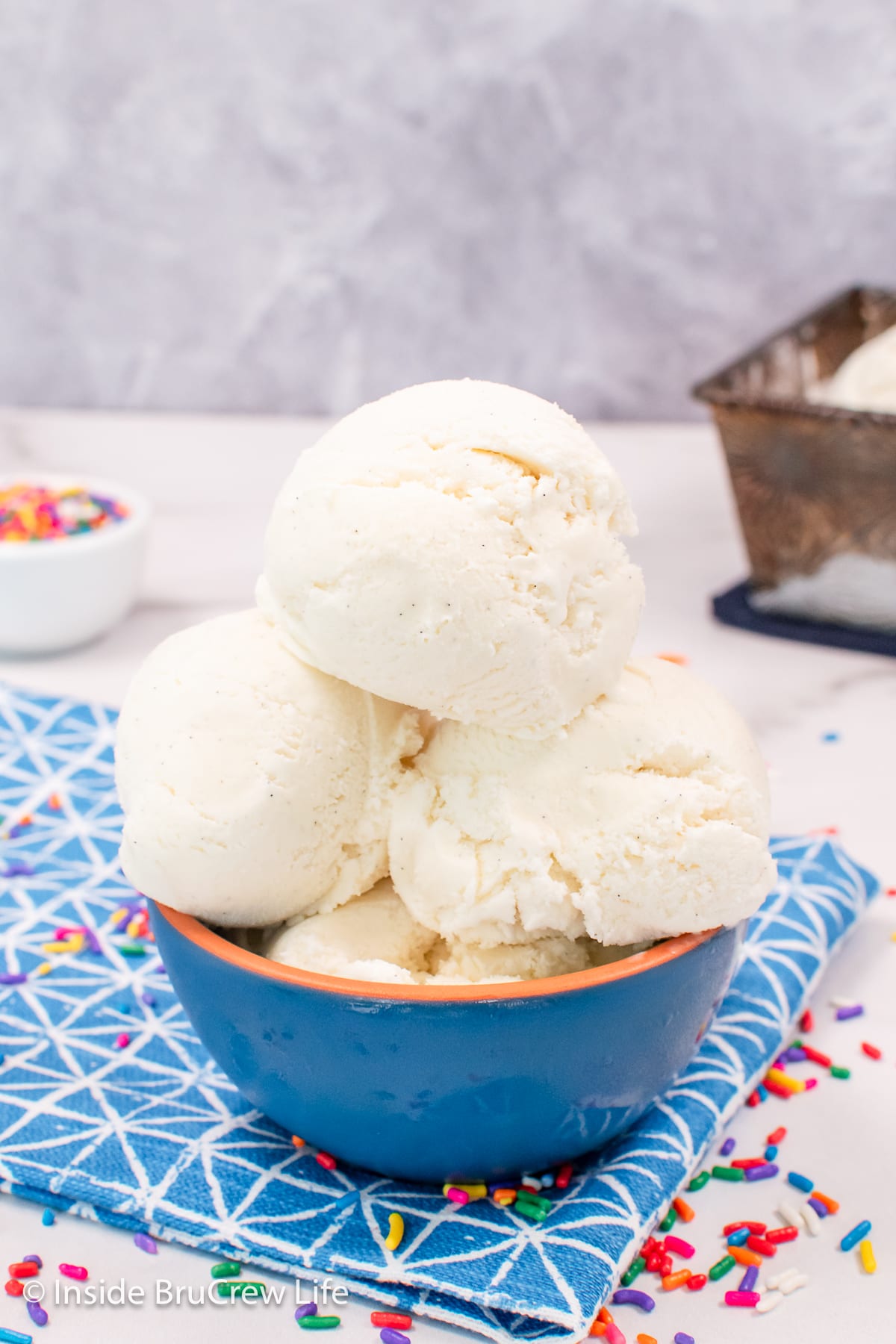 Scoops of vanilla ice cream in a blue bowl.