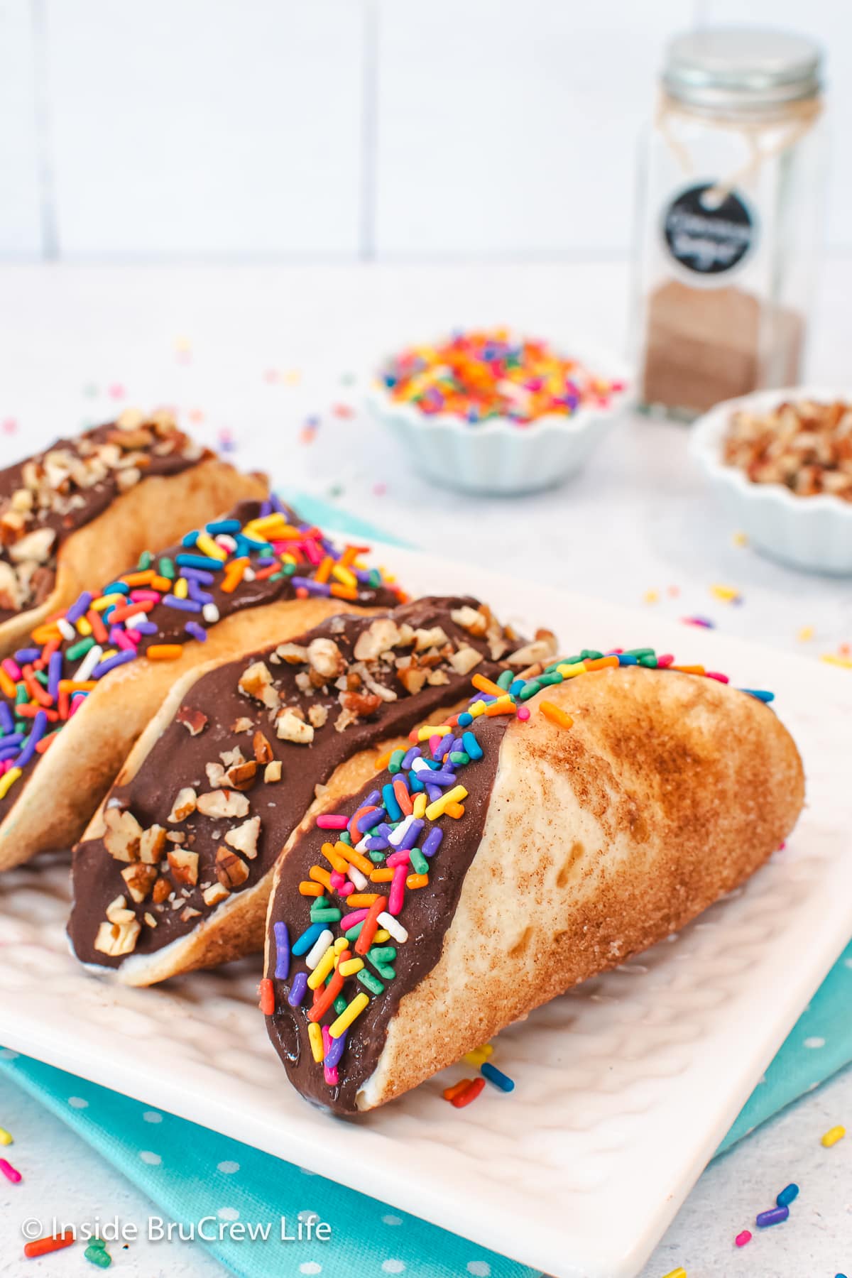 Cinnamon sugar tortillas filled with ice cream on a white tray.