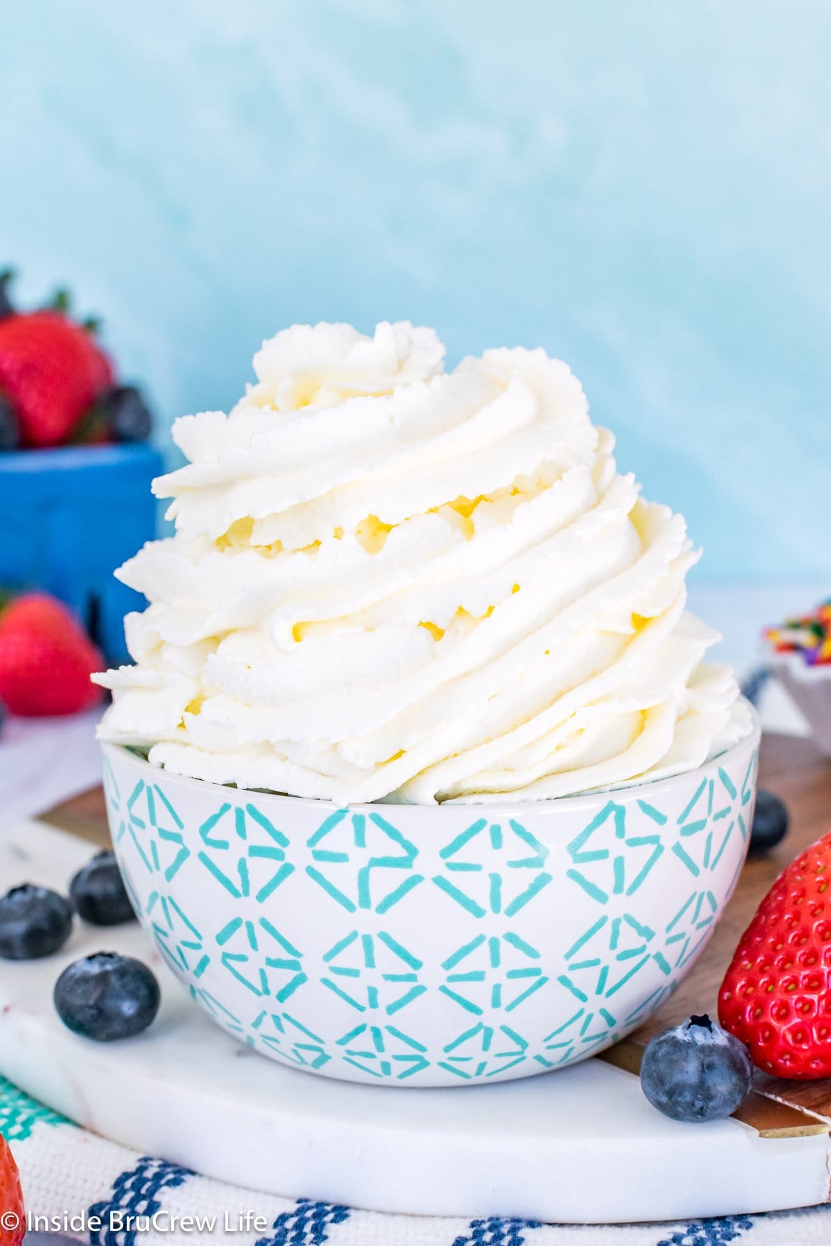A big swirl of whipped cream in a white and teal bowl.