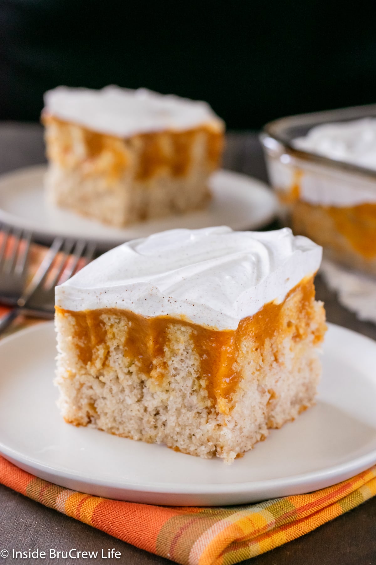 Squares of vanilla cake with pumpkin pudding on plates.