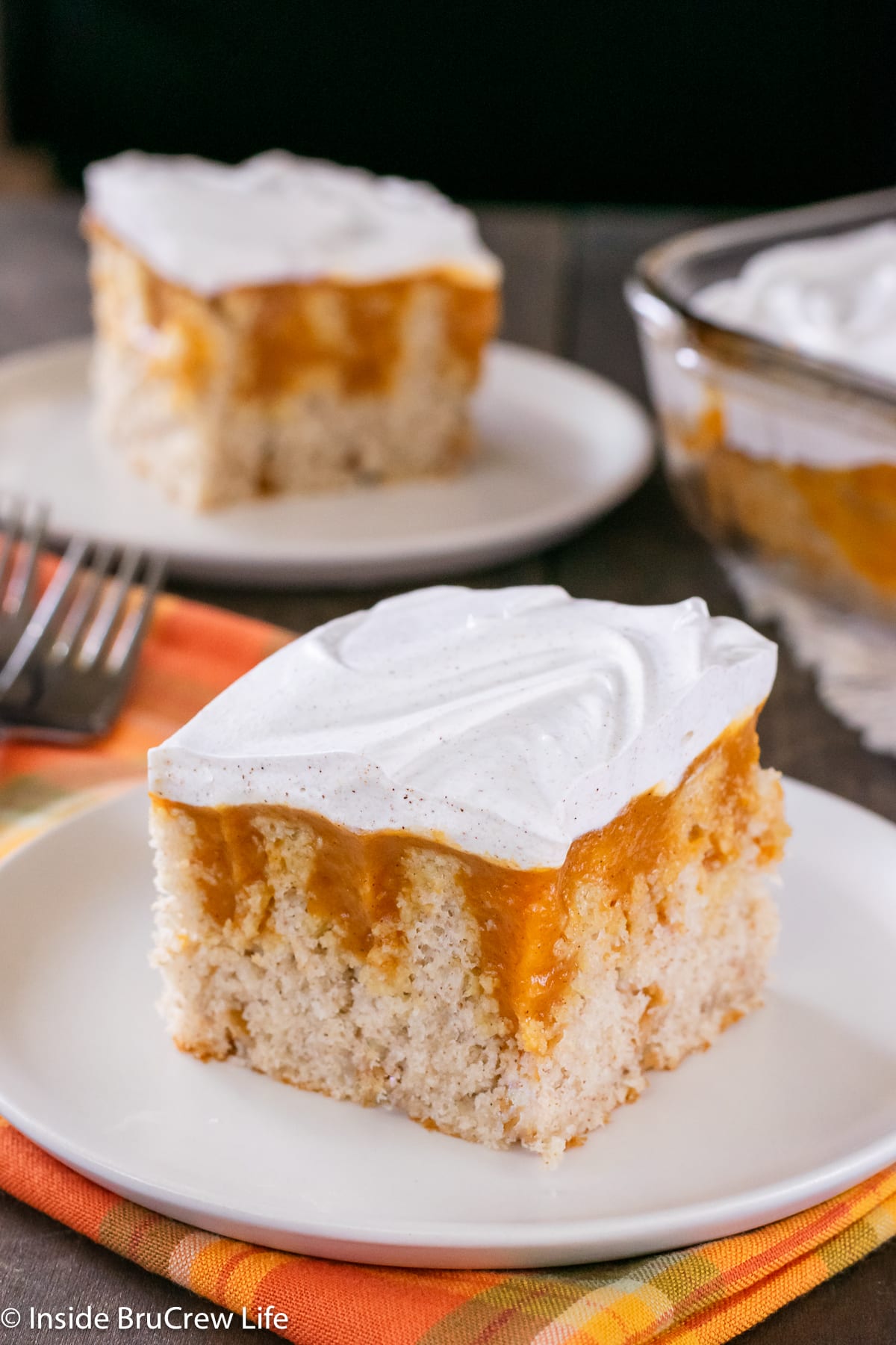 Two plates with pieces of vanilla cake with pumpkin pudding on them.