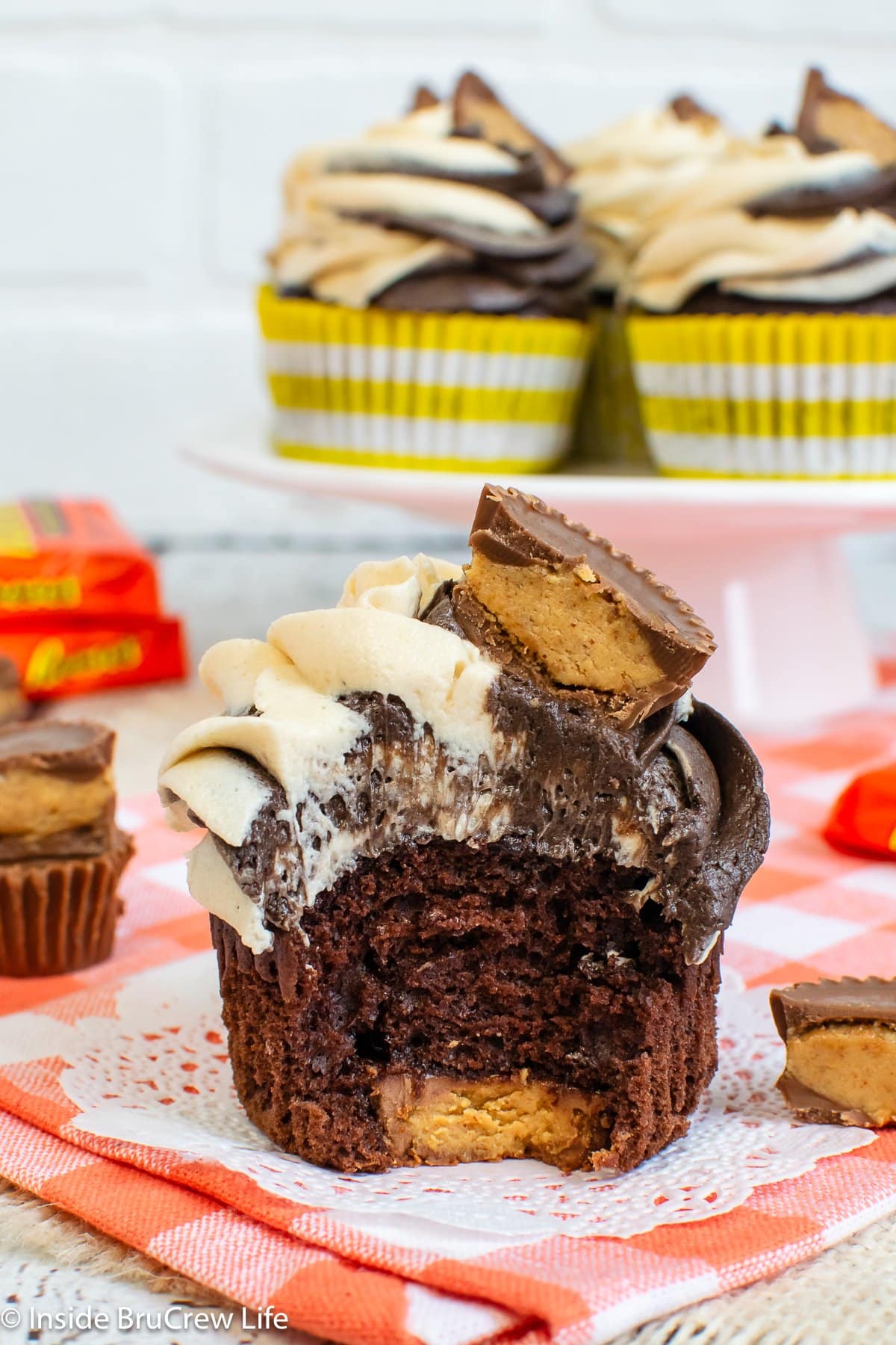 A chocolate cupcake with a peanut butter cup on the bottom.
