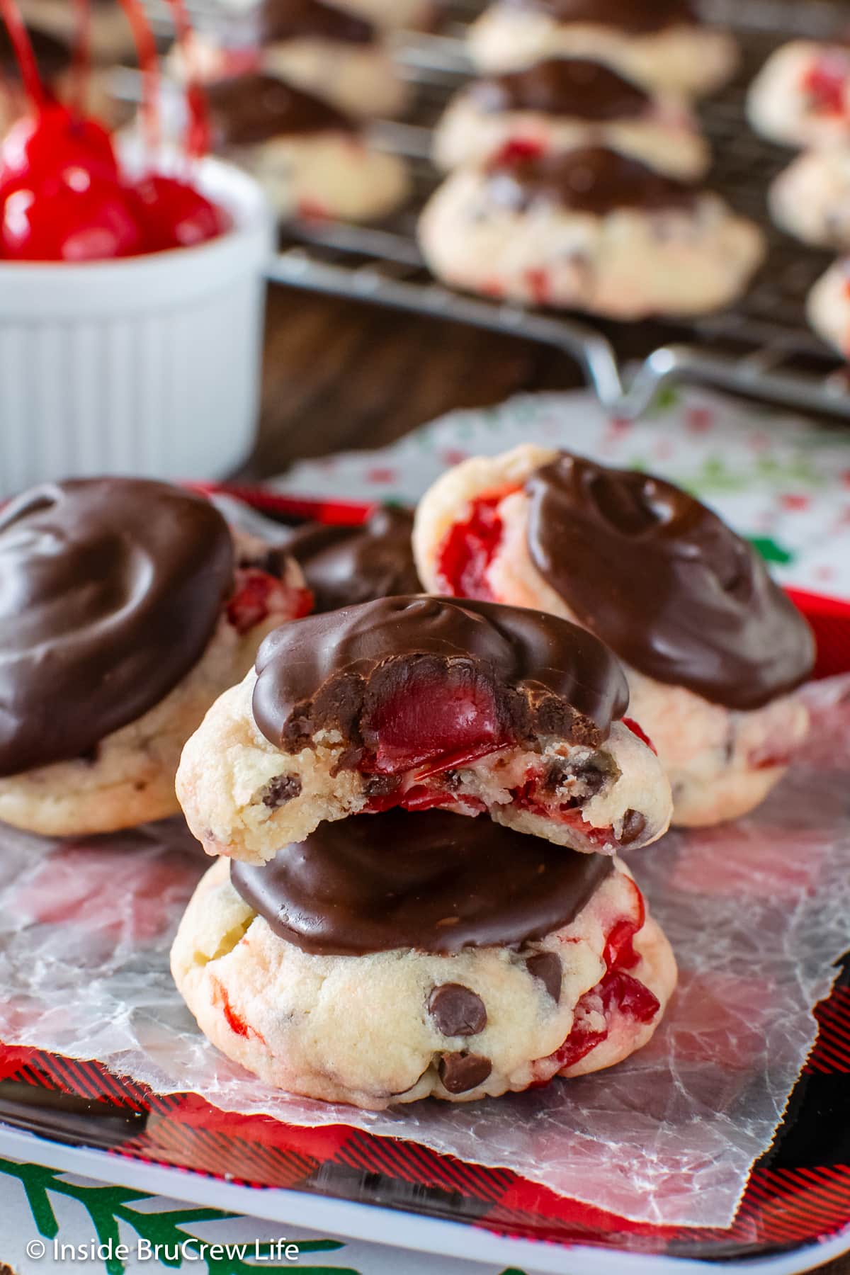 Cookies topped with cherries and chocolate on a plate.