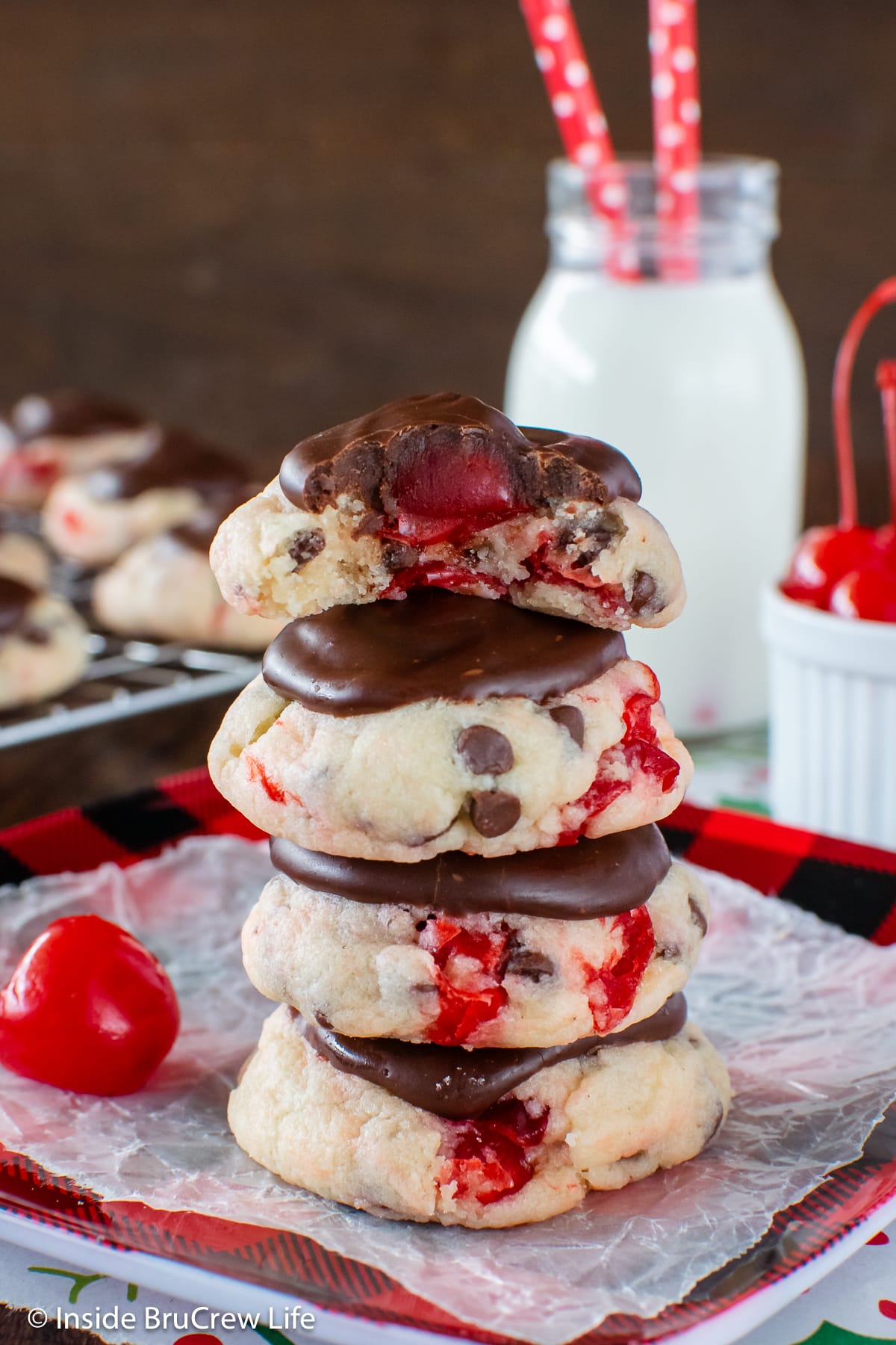 A stack of cake mix cookies topped with cherries and ganache.